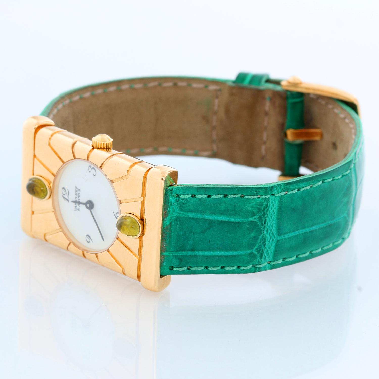 Van Cleef & Arpels Façade 18K Yellow Gold Vintage Watch - Quartz. 18K Yellow Gold  (22 mm x 33 mm) with green tourmaline on bezel. White dial with  Arabic numerals. Green strap with Van Cleef & Arpels tang buckle . Pre-owned with custom box .