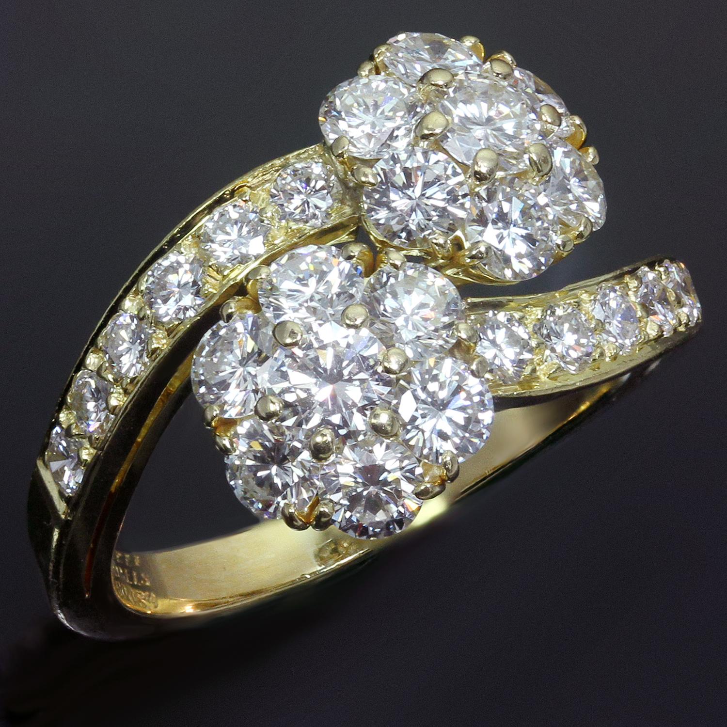 This gorgeous vintage Van Cleef & Arpels ring from the classic Fleurette collection features a Bypass double flower design crafted in 18k yellow gold and set with E-F-G VVS1-VVS2 brilliant-cut round diamonds weighing an estimated 2.50 carats. Made