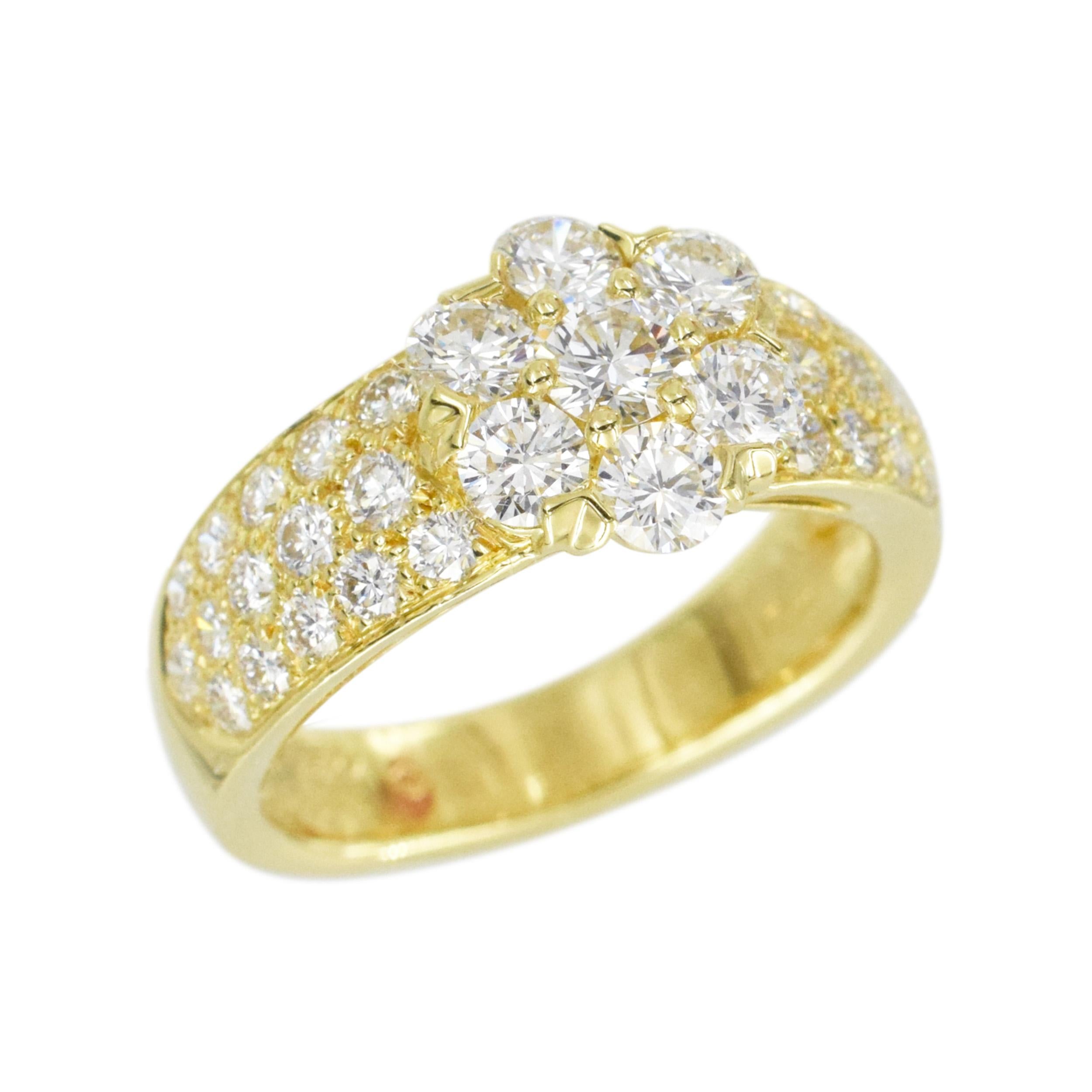 Van Cleef & Arpels diamond fleurette ring in 18k yellow gold. The ring features a
flower in the center, composed of 7 round brilliant cut diamonds, accented with shank half way pave set with 3 rows of round brilliant cut diamonds. There is of 37