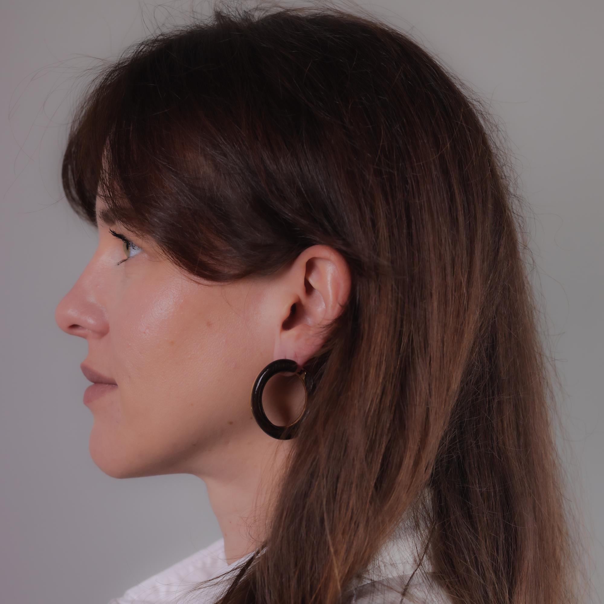 These vintage Van Cleef & Arpels earrings are crafted in 18k yellow gold and ebony wood, hallmarked with a signature, serial number, 