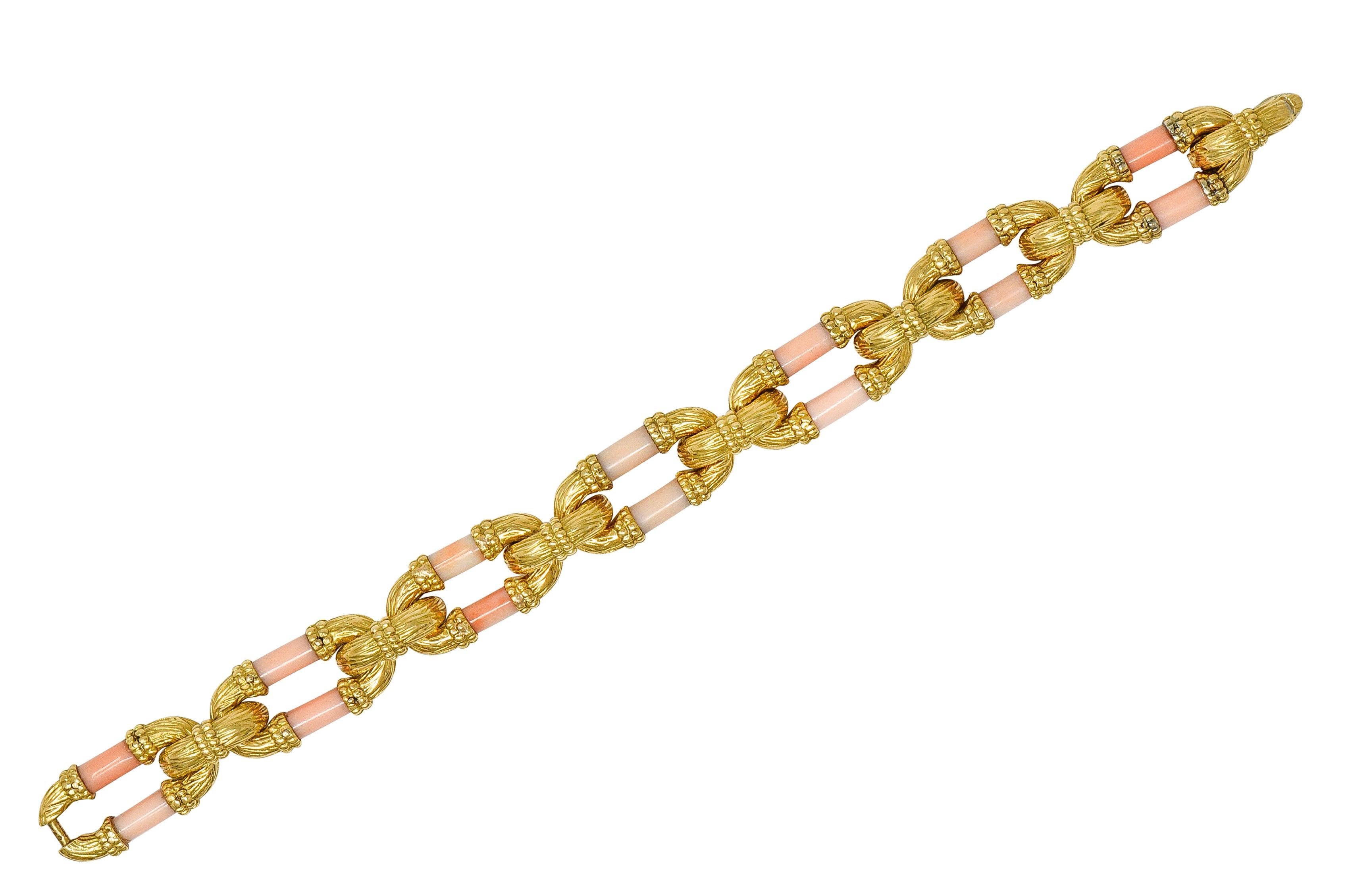 Designed as stylized cable style links with barrel shaped carved coral segments
Measuring 3.5 x 7.0 mm - opaque light pastel pinkish-orange with subtle mottling
With beaded gold detailing and grooved organic texture throughout
Completed by hidden