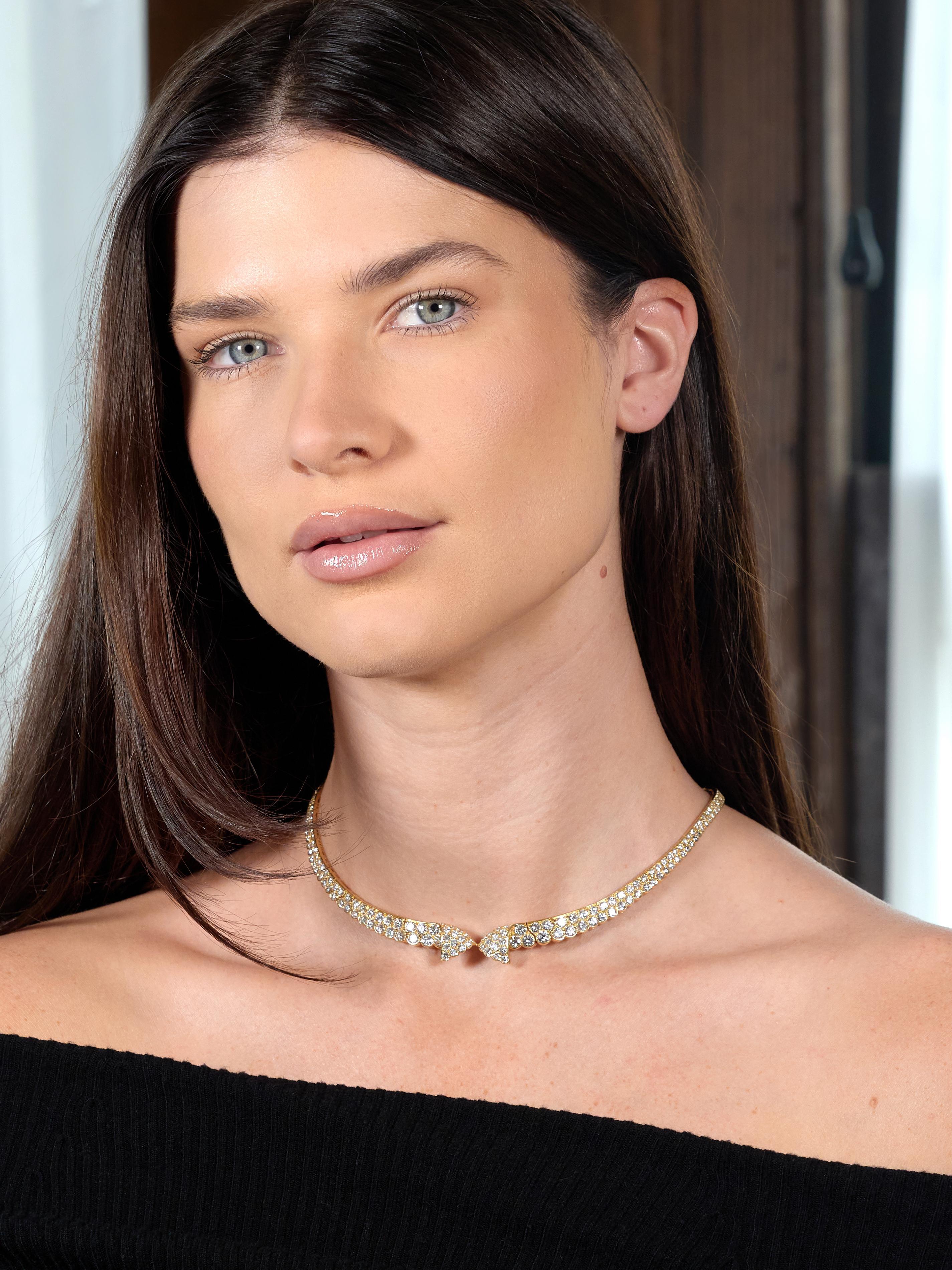 Conçu comme un collier à bavette composé de maillons articulés.
Centrage d'un motif de nœud plié et d'un bord inférieur festonné.
Perles serties de diamants ronds de taille brillant
D'un poids total d'environ 20.62 carat
Couleur D-G et clarté