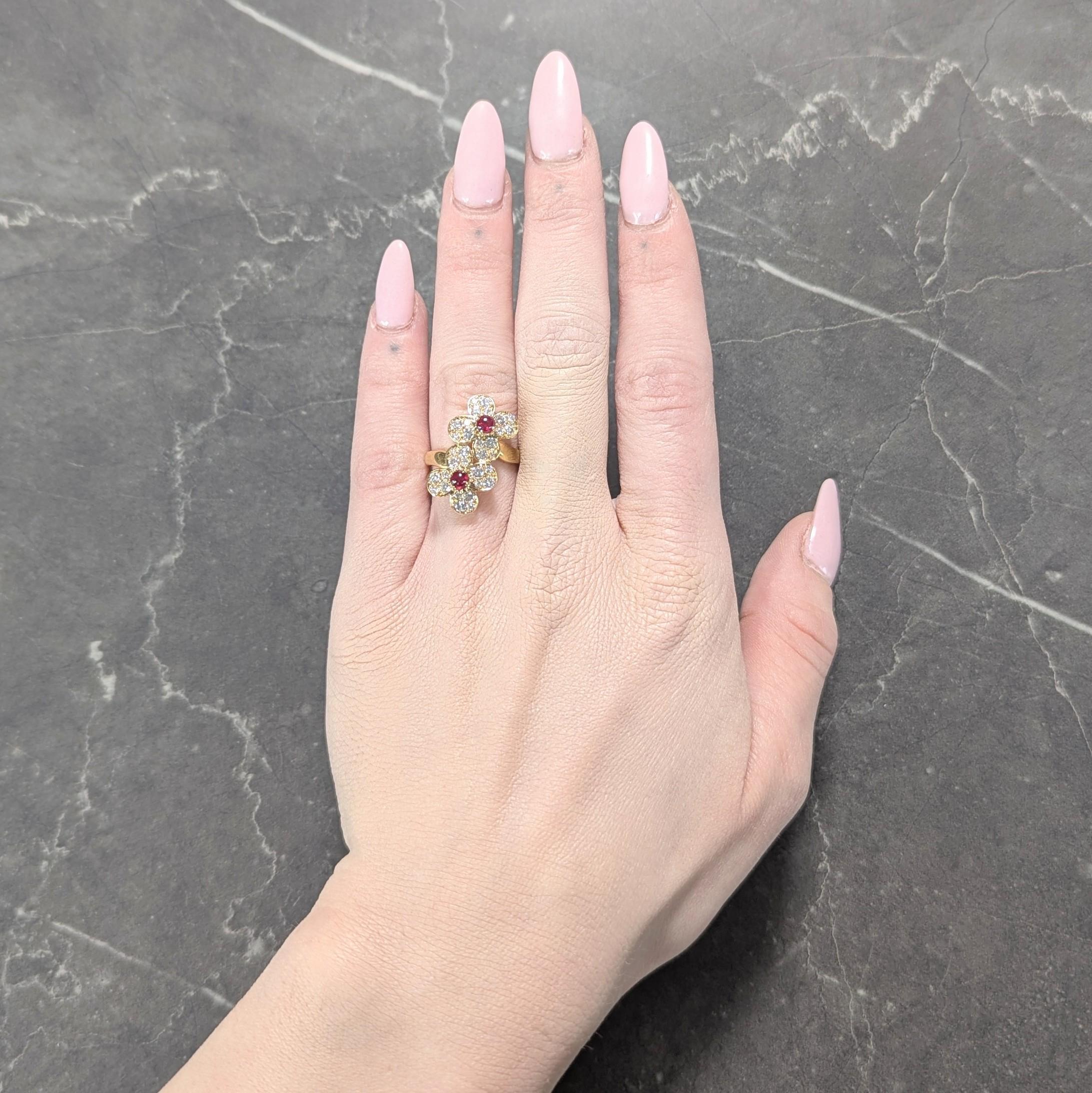 Conçu comme un anneau de style bypass torsadé se terminant par deux formes de fleurs stylisées.
Au centre, des cabochons de rubis taillés en rond - pesant environ 0,56 carats au total.
Transparent de couleur rouge moyen - avec un entourage de