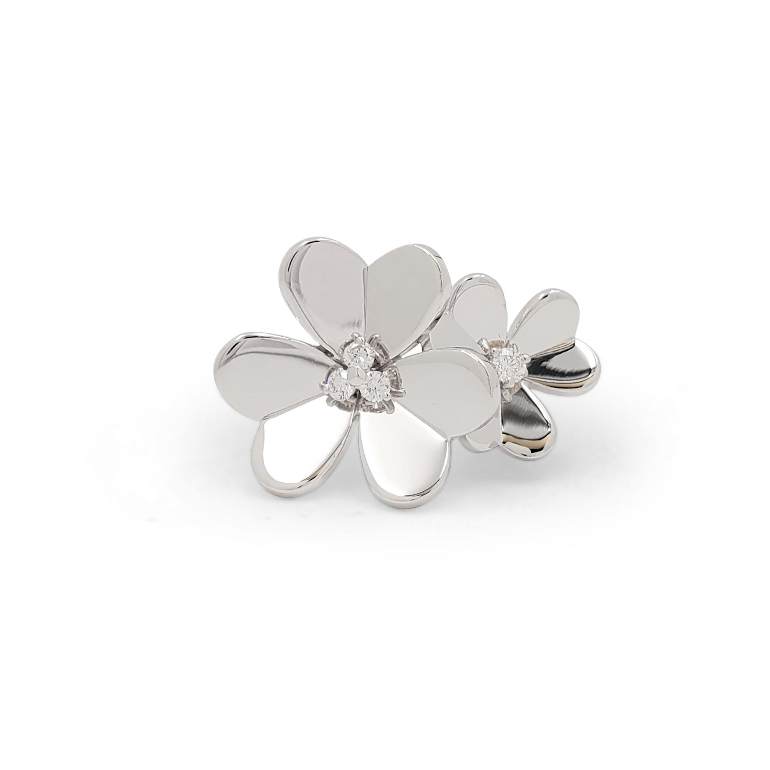 Authentic Van Cleef & Arpels 'Frivole' between-the-finger ring centers on two mirror-polished 18 karat white gold flowers with whimsical heart-shaped petals set at center with sparkling round brilliant cut diamonds. Signed VCA, 750, 47, with serial