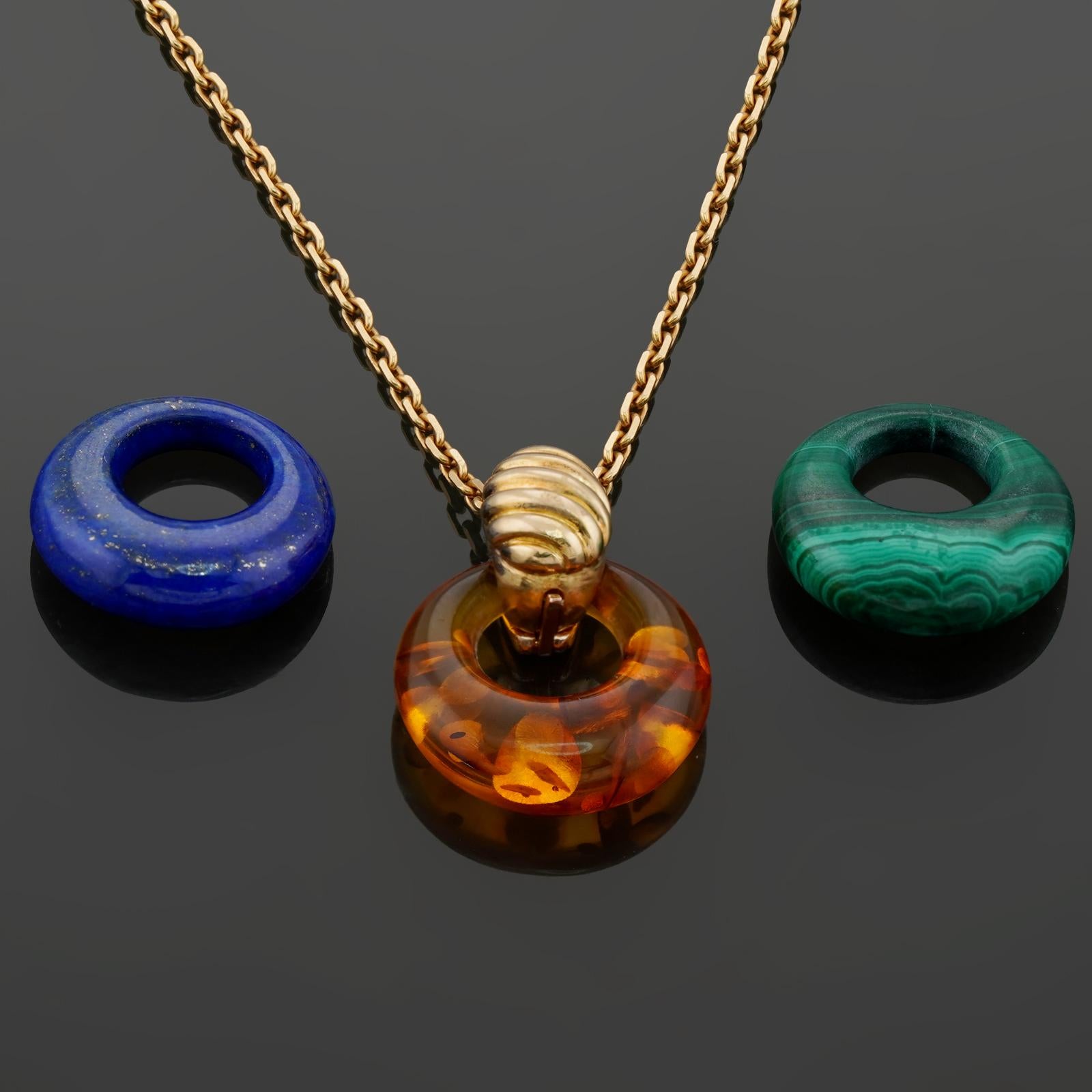 This gorgeous and versatile Van Cleef & Arpels necklace is crafted in 18k yellow gold and features 3 interchangable circular enhancer pendants crafted in amber, malachite, and lapis lazuli. Made in France circa 1980s. Measurements: 0.43