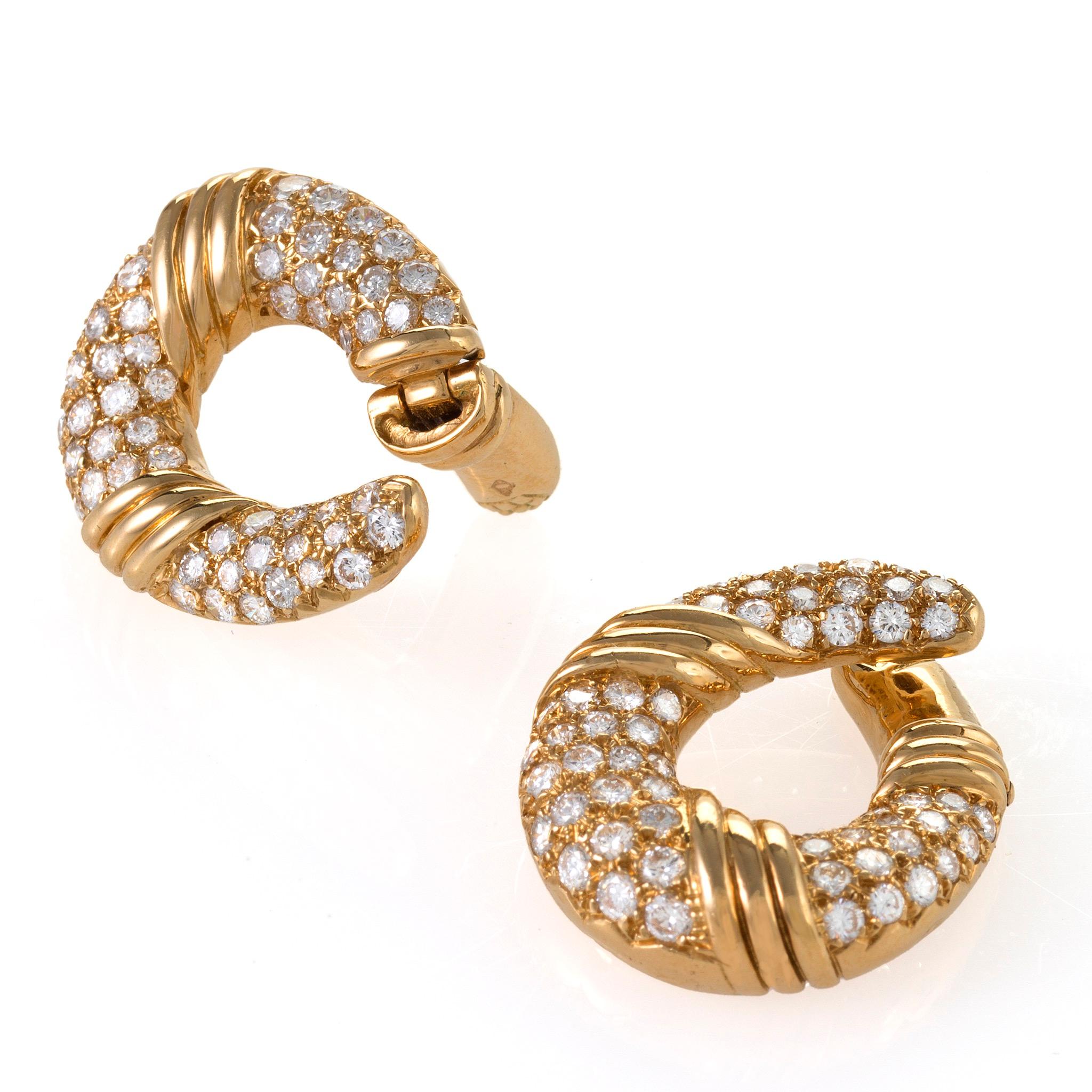 Dating from the 1960s, these Van Cleef & Arpels Paris hoop clipback earrings are composed of diamonds mounted in gold. Each earring is pave-set with round brilliant-cut diamonds, accented by polished gold triple arched bands. Ideally modeled to