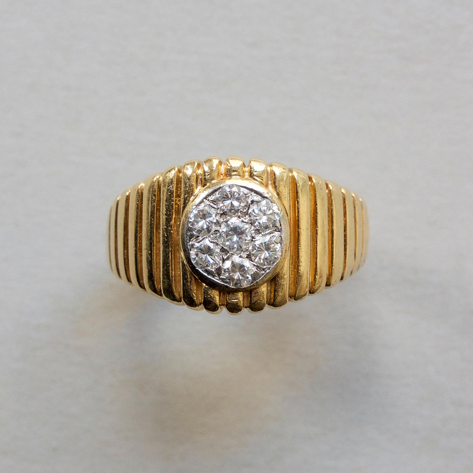 An 18 carat gold ring set with zeven round, brilliant cut diamonds. The shank is ribbed and the diamonds are set in a circle with one stone in the middle and the others in a circle around it. (app. 0.20 carats in total), signed and numbered: VCA @