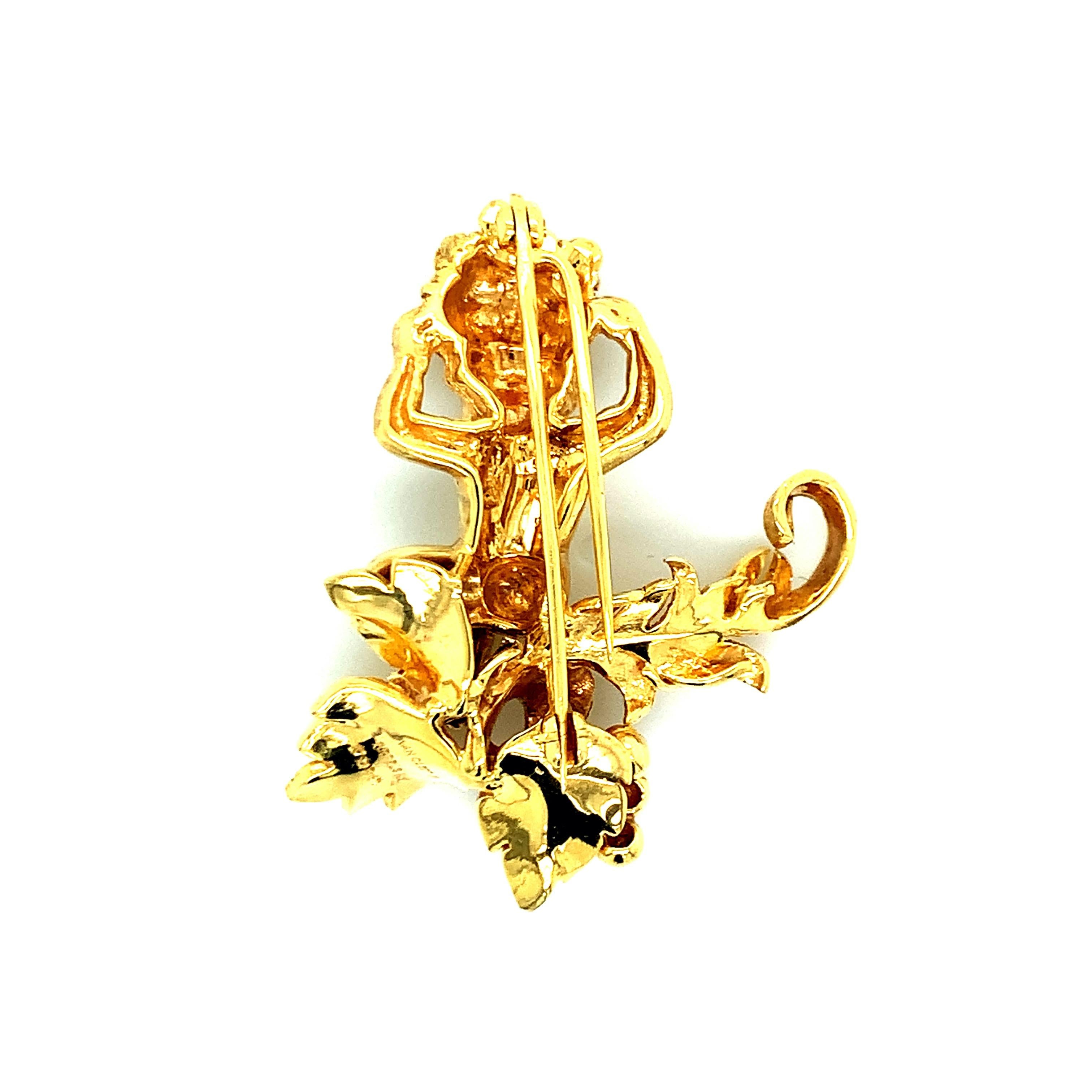 Van Cleef & Arpels 18 karat yellow gold brooch with a human motif, carrying a basket filled with various goods on her head. She is sitting on a grape vine. Total weight: 19.6 grams. Length: 4.4 cm. Width: 3.6 cm. 

Signed Van Cleef & Arpels
