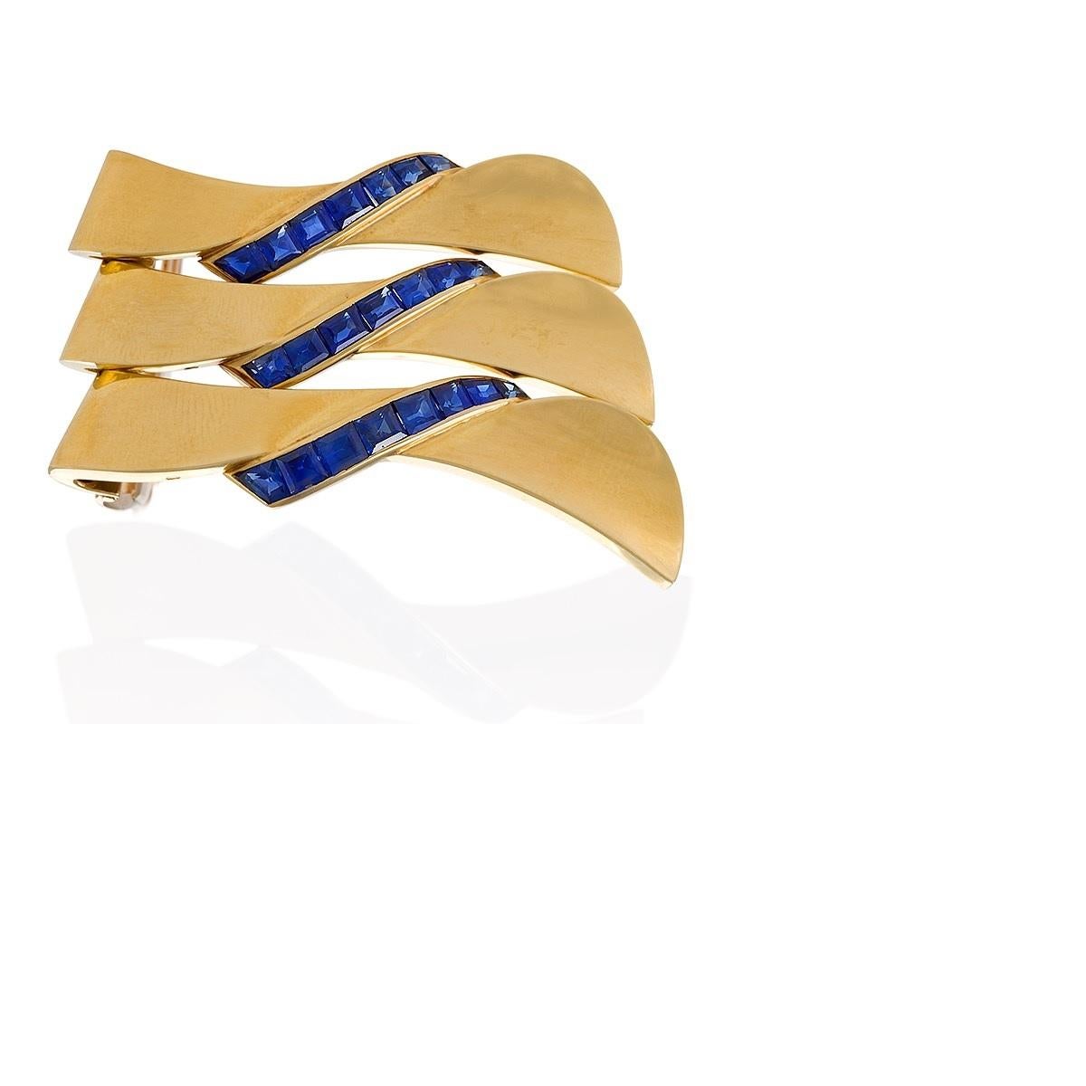 A convertible French 18 karat gold clip brooch with calibre-cut sapphires by Van Cleef & Arpels. The brooch, convertible into a set of three, is highlighted by channel-set lines of 22 calibre-cut sapphires with an approximate total weight of 2.90
