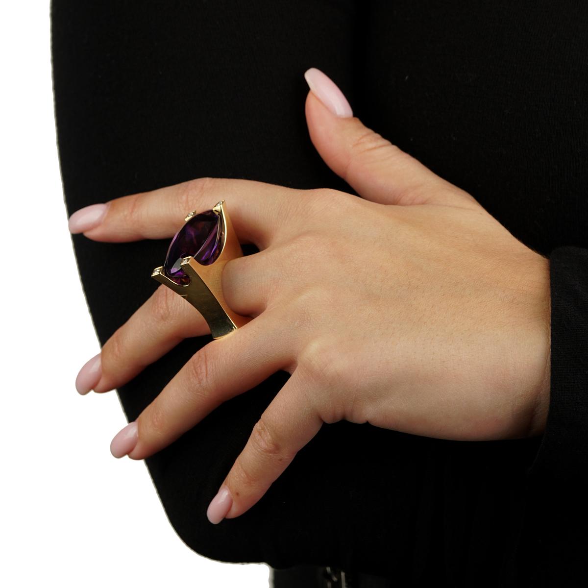 A fabulous Van Cleef and Arpels cocktail ring featuring a vivid amethyst encased by 4 of the finest Van Cleef and Arpels round brilliant cut diamonds in 18k yellow gold. The ring measures a size 6 1/4

Weight : 45.8 grams
