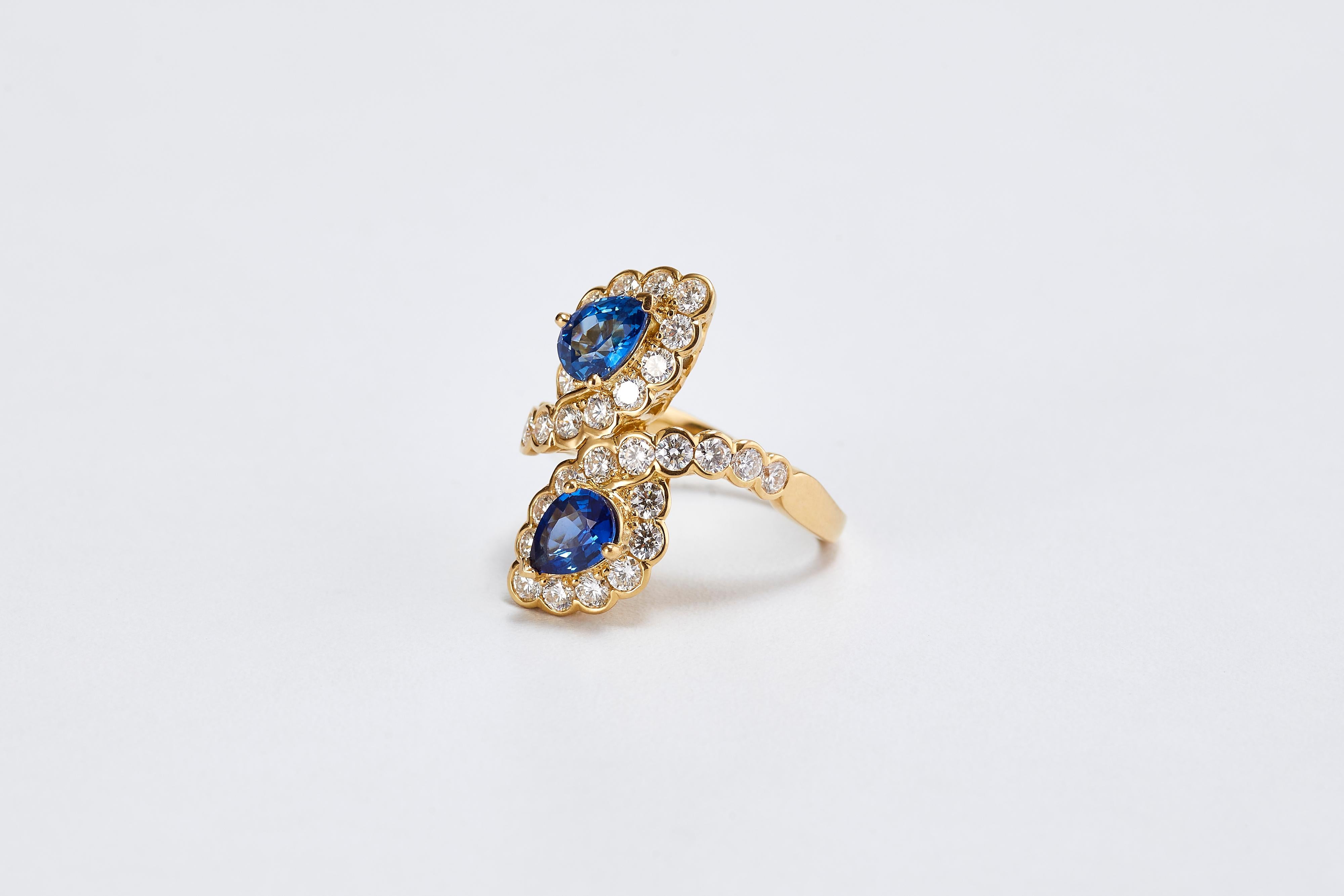 Van Cleef & Arpels Goldring mit 2 birnenförmigen blauen Saphiren und Diamanten.
Ein wunderschöner VCA-Ring aus 18 Karat Gelbgold. Mit 2 blauen, birnenförmig geschliffenen Saphiren in der Mitte. 
Die Abmessungen der Saphire sind ca. 6,30 x 5 mm, mit