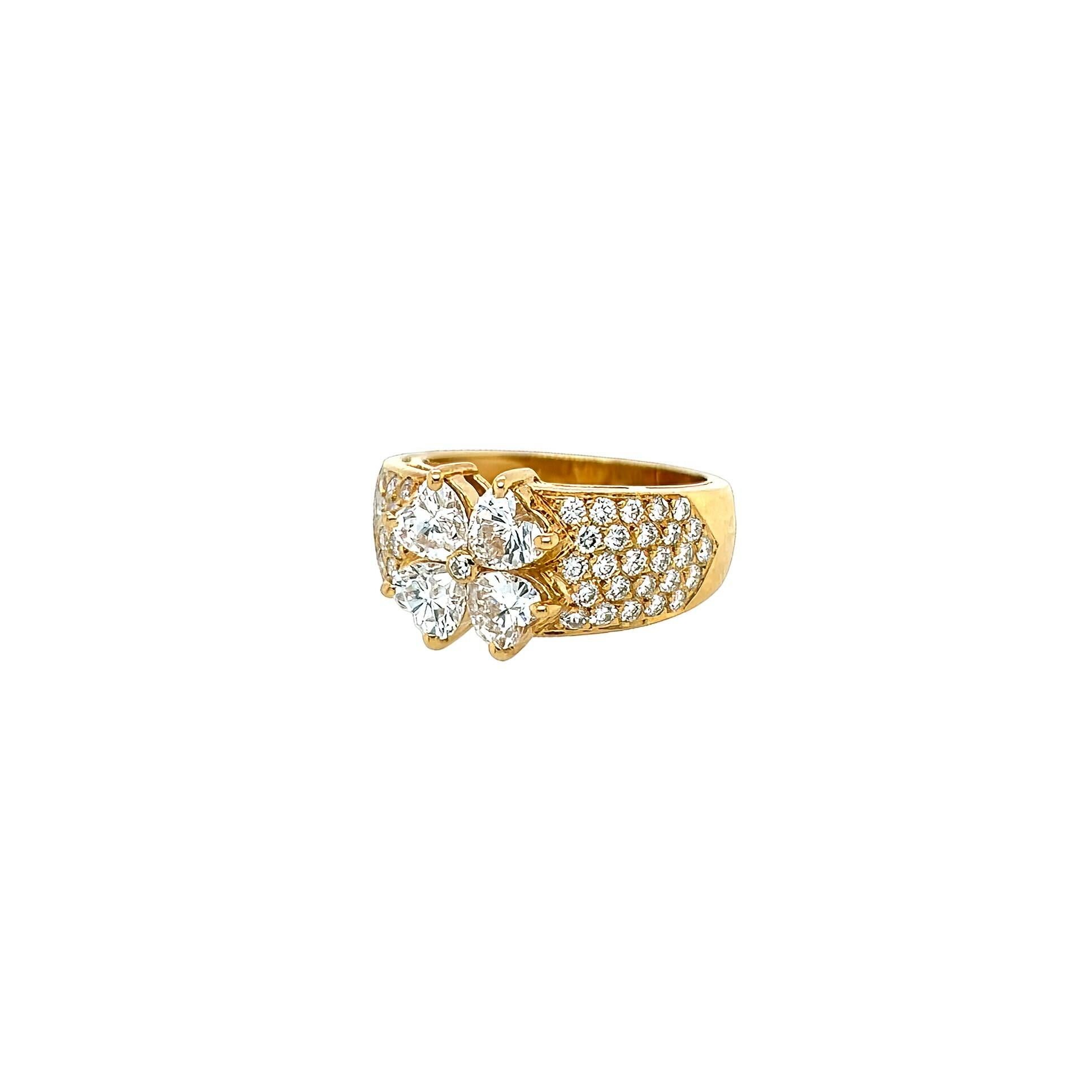 Bague en or jaune 18 carats et diamants, Van Cleef & Arpels, France.  Quatre diamants en forme de cœur formant une fleur au centre de laquelle se trouve un diamant rond de taille brillant, la large bande est sertie d'environ 52 diamants ronds de