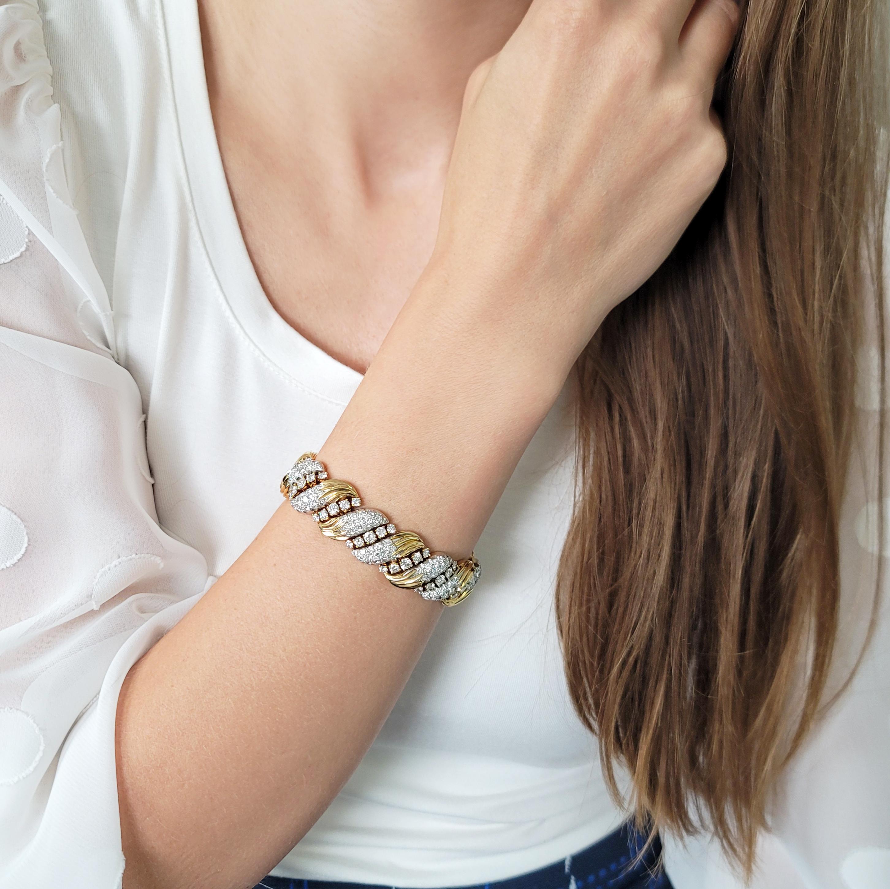 From Van Cleef & Arpels  'Heritage Collection'
diamond bracelet, designed as an alternating 14 links of
single row of 5 prong set round diamonds and 14 nature inspired yellow gold and platinum links, each
pave set with 14 round diamonds, secured