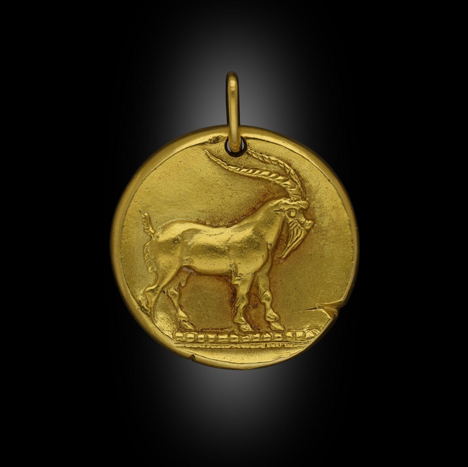 Ein Zodiac-Anhänger aus 18-karätigem Gold von Georges Lenfant für Van Cleef & Arpels, um 1960. Der runde, scheibenförmige Anhänger für das 10. Zeichen Steinbock ist wie eine antike Münze gestaltet, die Vorderseite mit dem erhabenen Bild einer