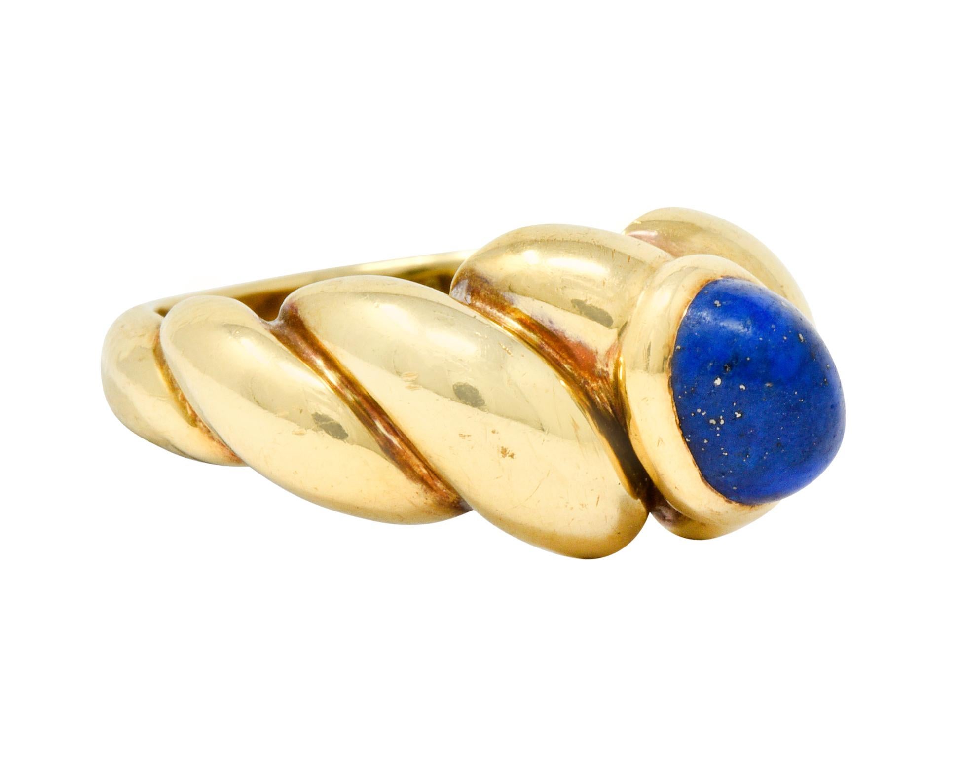 Centering a bezel set oval lapis cabochon measuring approximately 7.3 x 5.4 mm, ultramarine blue in color with flecks of gold pyrite

Completed by a dynamically twisted band with a polished gold finish

Maker's mark for Van Cleef & Arpels and