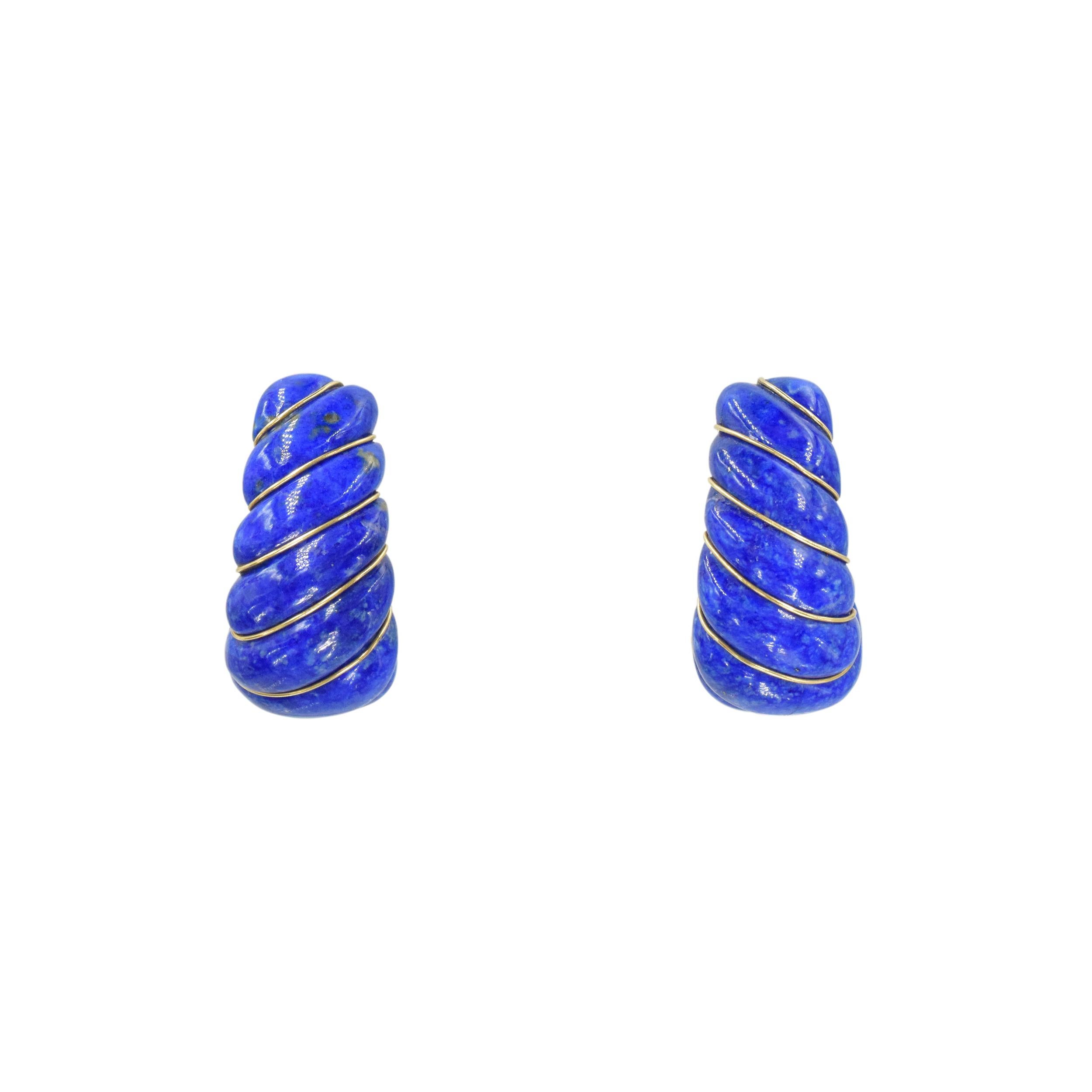 Van Cleef & Arpels lapis lazuli and 18k yellow gold shrimp style earclips. This
pair of earrings consisit of ribbed lapis lazuli accented with 18k gold wire placed between the grooves. Equipped with omega back clip. Inscribed: VCA, Serial No,.