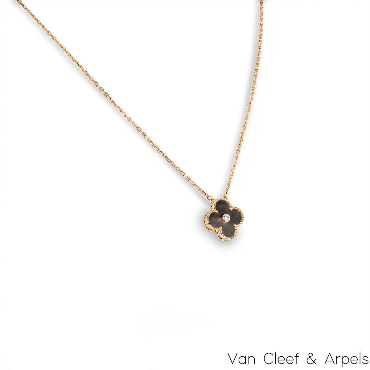 Pendente Van Cleef & Arpels Vintage Alhambra in edizione limitata in oro rosa 18k, madreperla grigia e diamanti, della collezione Holiday 2014. Il ciondolo presenta un motivo a quadrifoglio con bordi in rilievo e un intarsio in madreperla grigia. A
