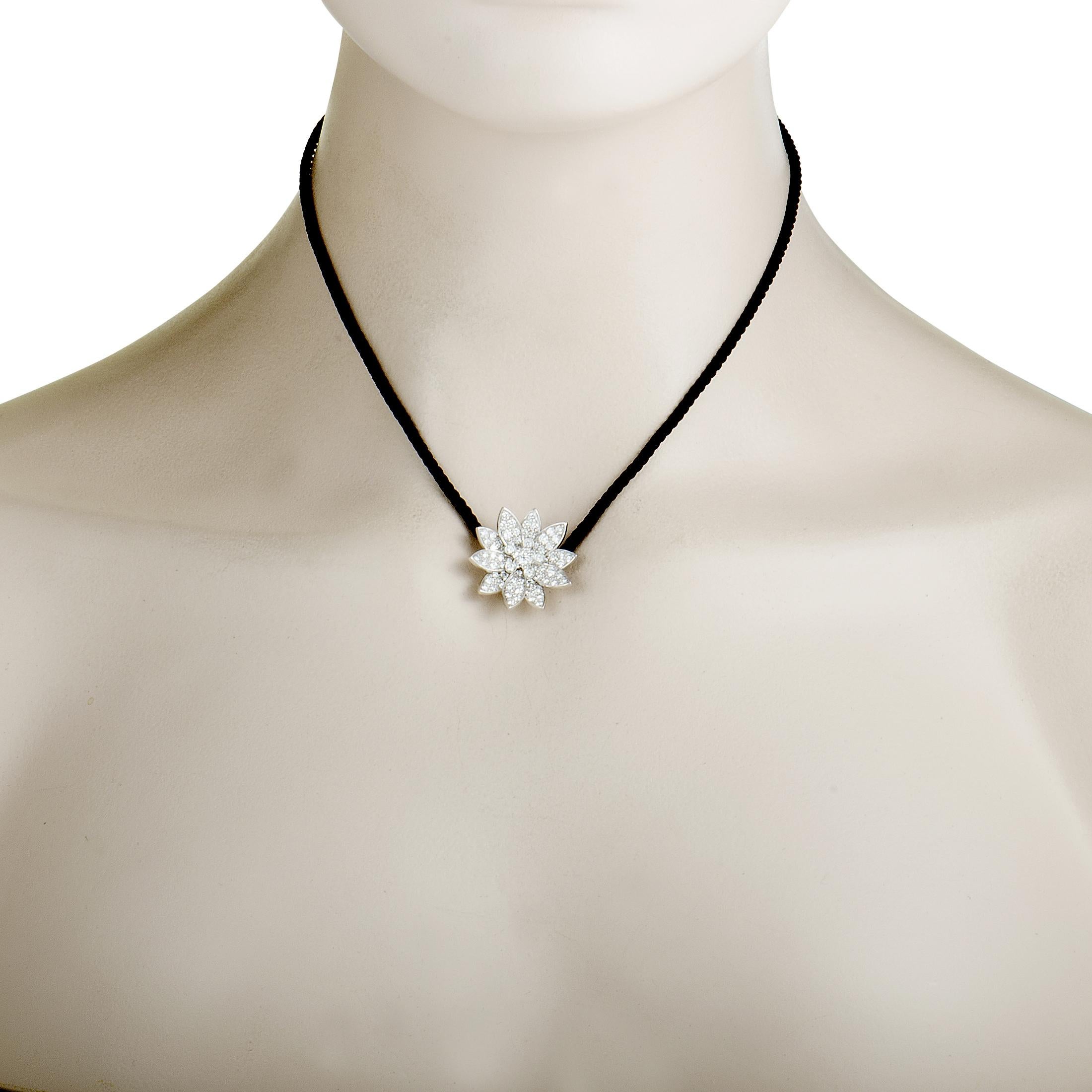 This extraordinarily envisioned Van Cleef & Arpels necklace from the exceptional “Lotus” collection is presented with an attractive black cord onto which a stunningly extravagant lotus pendant is attached. The pendant is crafted from 18K white gold
