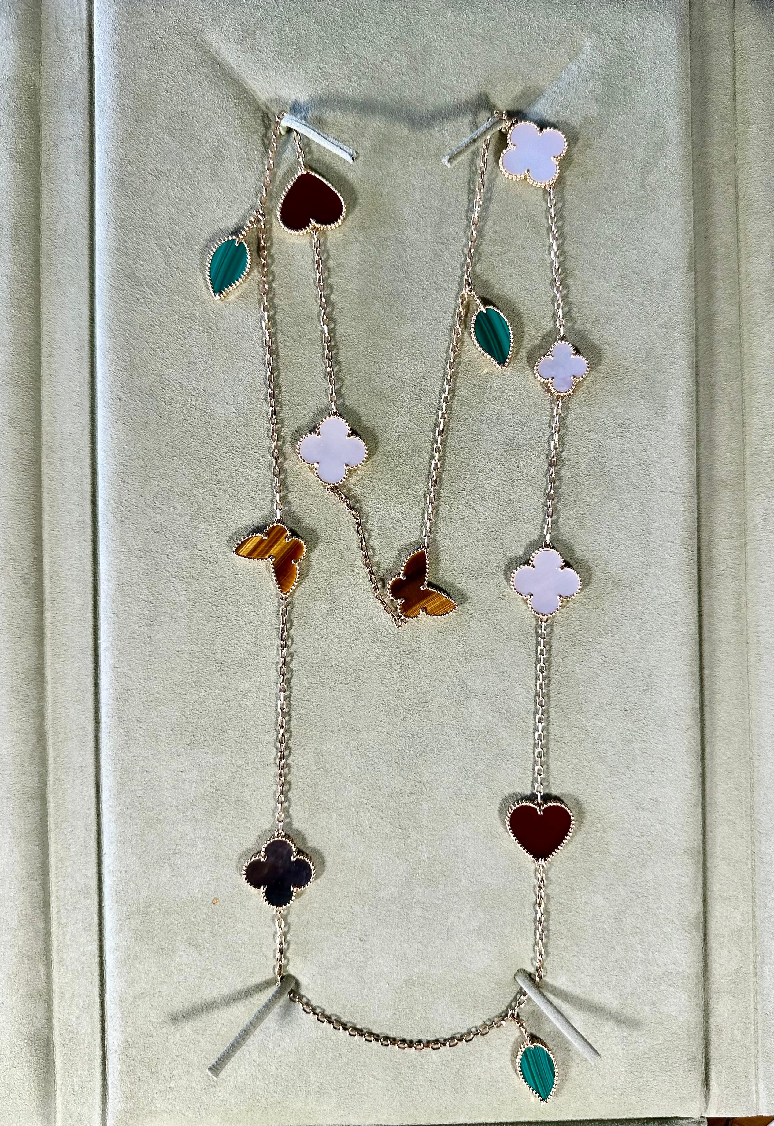 Lucky Alhambra long necklace, 12 motifs, 18K yellow gold, carnelian, tiger’s eye, white and gray mother-of-pearl, malachite.
This necklace is not Van Cleef 
Carnelian: 2 stones
Malachite: 3 stones
Mother-of-pearl: 5 stones
Tiger Eye: 2