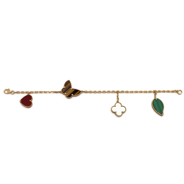 Authentic Van Cleef & Arpels Lucky Alhambra bracelet crafted in 18 karat yellow gold.   The four motif bracelet features some of the brand's most iconic symbols: a malachite leaf, a mother-of-pearl clover motif, a tiger's eye butterfly, and a