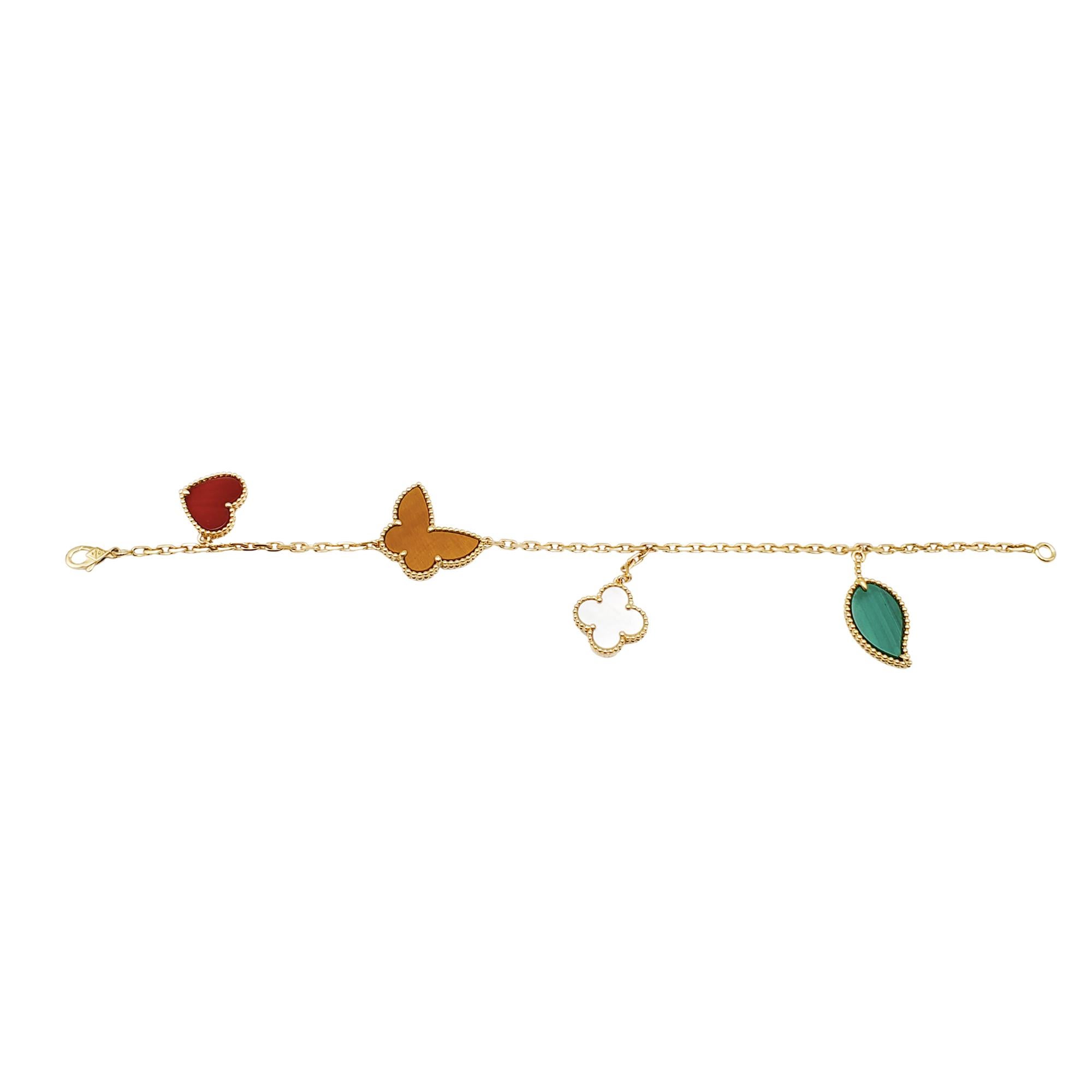 Authentic Van Cleef & Arpels Lucky Alhambra bracelet crafted in 18 karat yellow gold. The four motif bracelet features some of the brand's most iconic symbols: a malachite leaf, a mother-of-pearl clover motif, a tiger's eye butterfly, and a