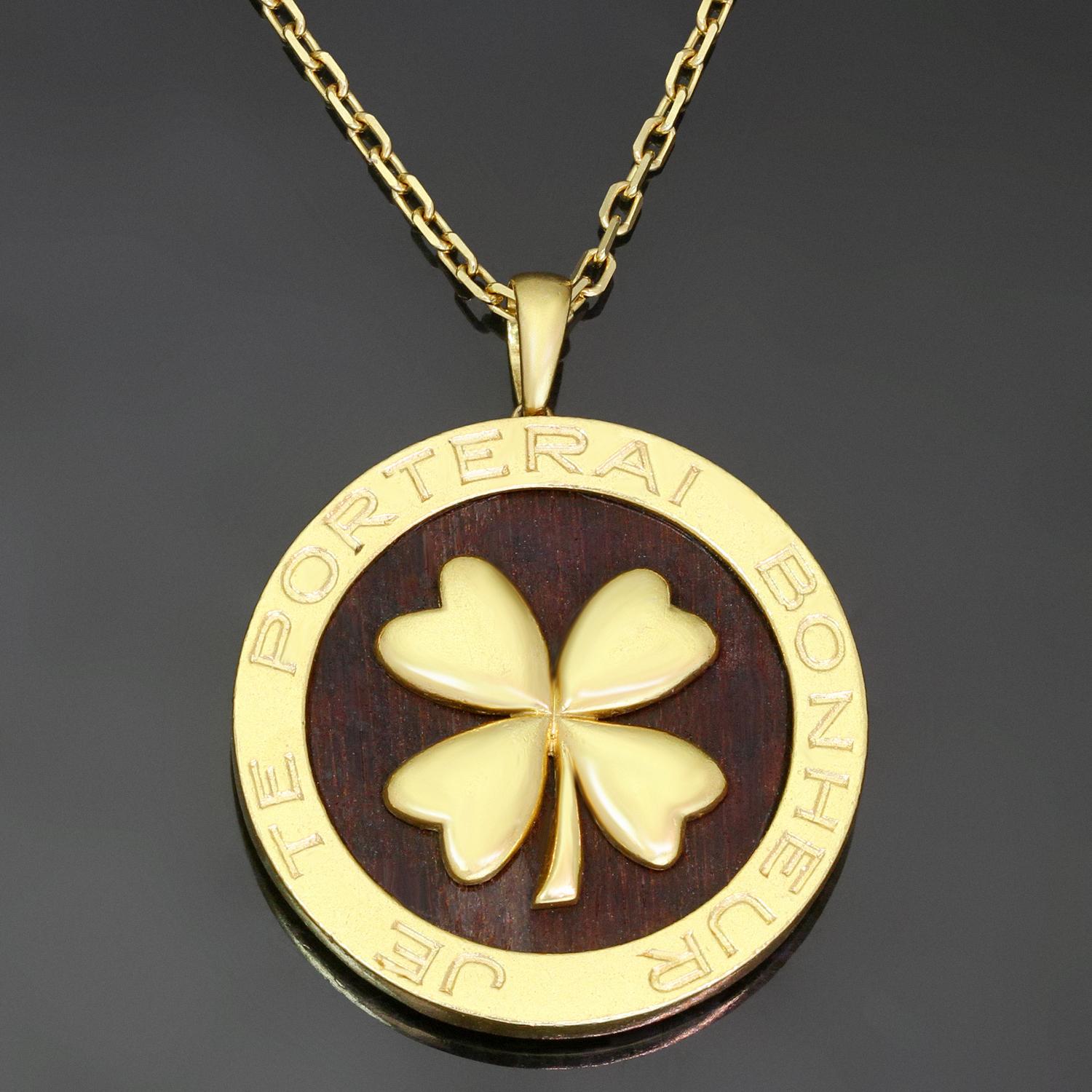 This rare Van Cleef & Arpels necklace is crafted in 18k yellow gold and features a round wooden bois d'amourette pendant accented with a four-leaf lucky clover and encircled with a text 'Je Te Porterai Bonheur' for 'I Will Bring You Luck'. Signed