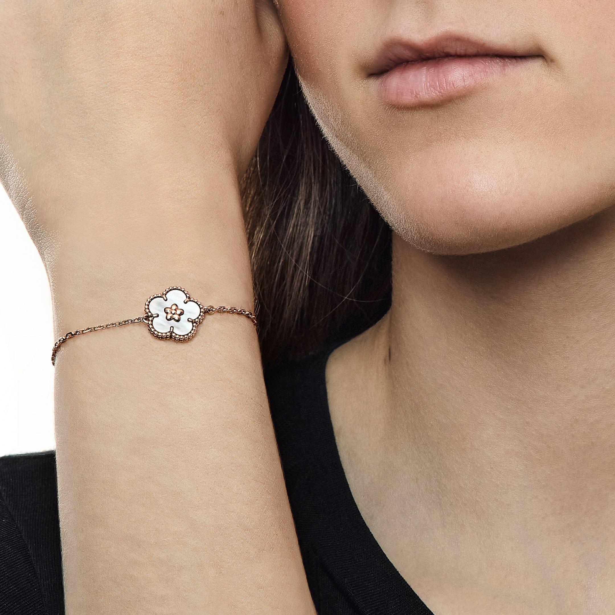 Le bracelet Lucky Spring présente un motif unique de fleur de prunier façonné en nacre lumineuse, serti dans de l'or rose 18 carats chaleureux. La douce irisation de la pierre de nacre contraste magnifiquement avec les pétales raffinés en or rose,