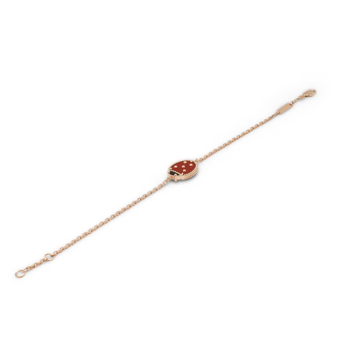 Authentic Van Cleef & Arpels 'Lucky Spring' bracelet crafted in 18 karat rose gold features a single closed wings ladybug motif set with carved carnelian and onyx. The adjustable chain measures 6 3/4 (17cm) in length. Signed VCA, 750, with serial