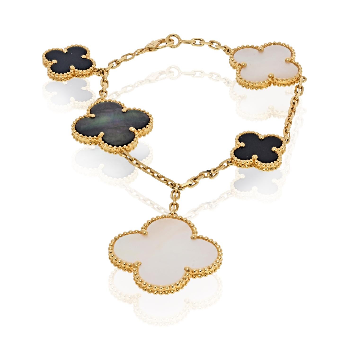 Ce bracelet Van Cleef & Arpels Magic Alhambra présente cinq motifs de trèfle emblématiques façonnés en or jaune 18 carats, associant trois pierres de nacre blanche et grise à deux pierres d'onyx. Chaque pierre est unique, avec des variations