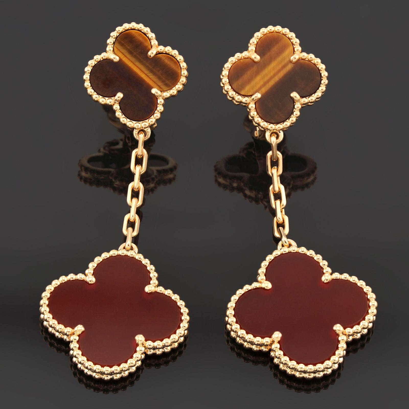 These gorgeous Van Cleef & Arpels 2-motif drop earrings from the iconic Magic Alhambra collection are crafted in 18k yellow gold and feature lucky clover motifs set with tiger's eye and carnelian in round bead settings. Made in France circa 2018.