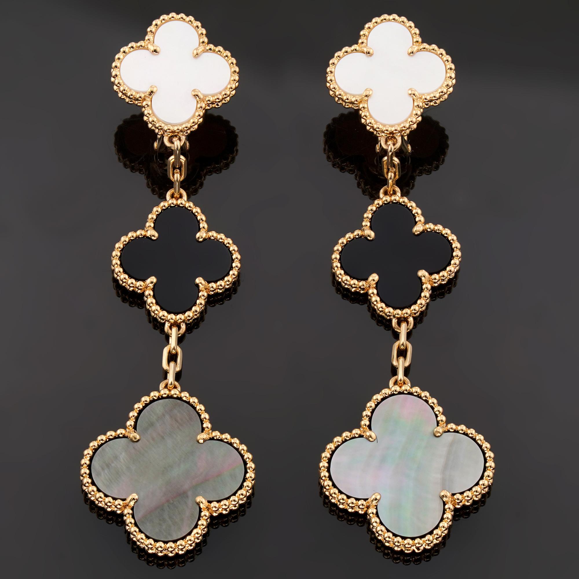 Questi squisiti orecchini Van Cleef & Arpels, appartenenti all'iconica collezione Magic Alhambra, presentano un design a tre motivi di quadrifogli in rilievo realizzati in oro giallo 18 carati e incastonati con onice e madreperla bianca e grigia.