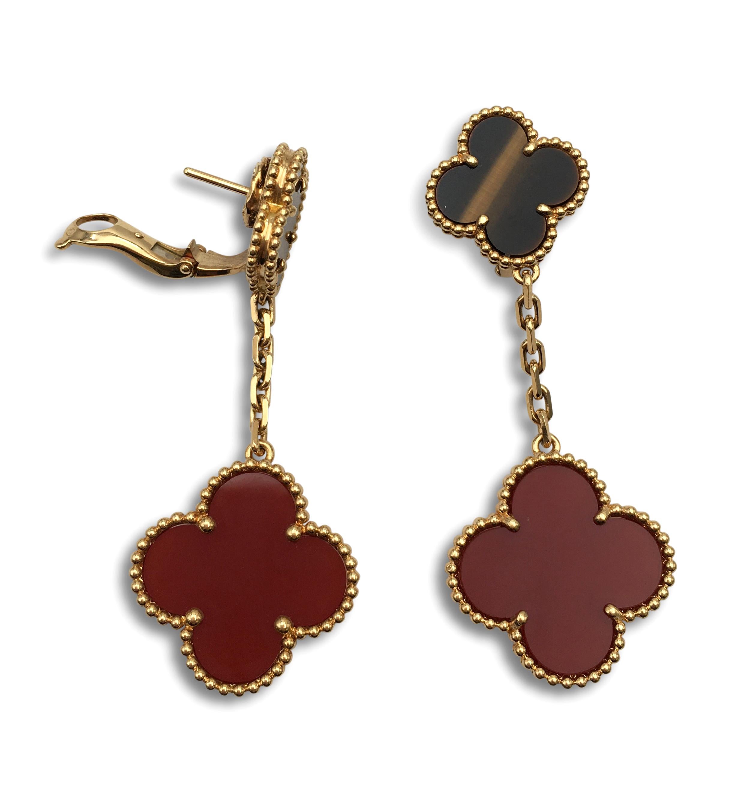 Authentic Van Cleef & Arpels 'Magic Alhambra' earrings crafted in 18 karat yellow gold featuring two different-sized Alhambra clover motifs; one made from carnelian and the other with tigers eye stone. Signed VCA, Au750, with serial number. The