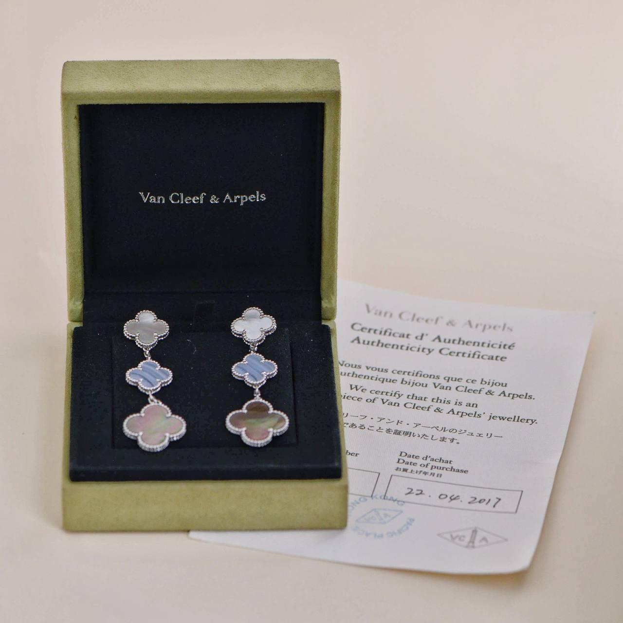*Rare Find* 

Exude elegance with these stunning Magic Alhambra earrings from Van Cleef & Arpels. Crafted from 18k white gold, this exquisite pair showcases three motifs featuring a harmonious blend of mother of pearl and Chalcedony. The delicate