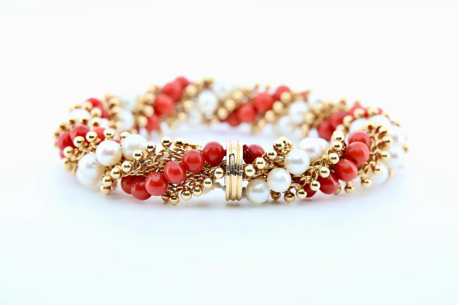 A mid century Van Cleef & Arpels Twist motif bracelet set with Coral and Pearls.

Crafted as a helix design, and adorned with intertwined strands of cultured pearls, and natural polished coral.

Hallmarked as 18 Karat Gold with French hallmarks.