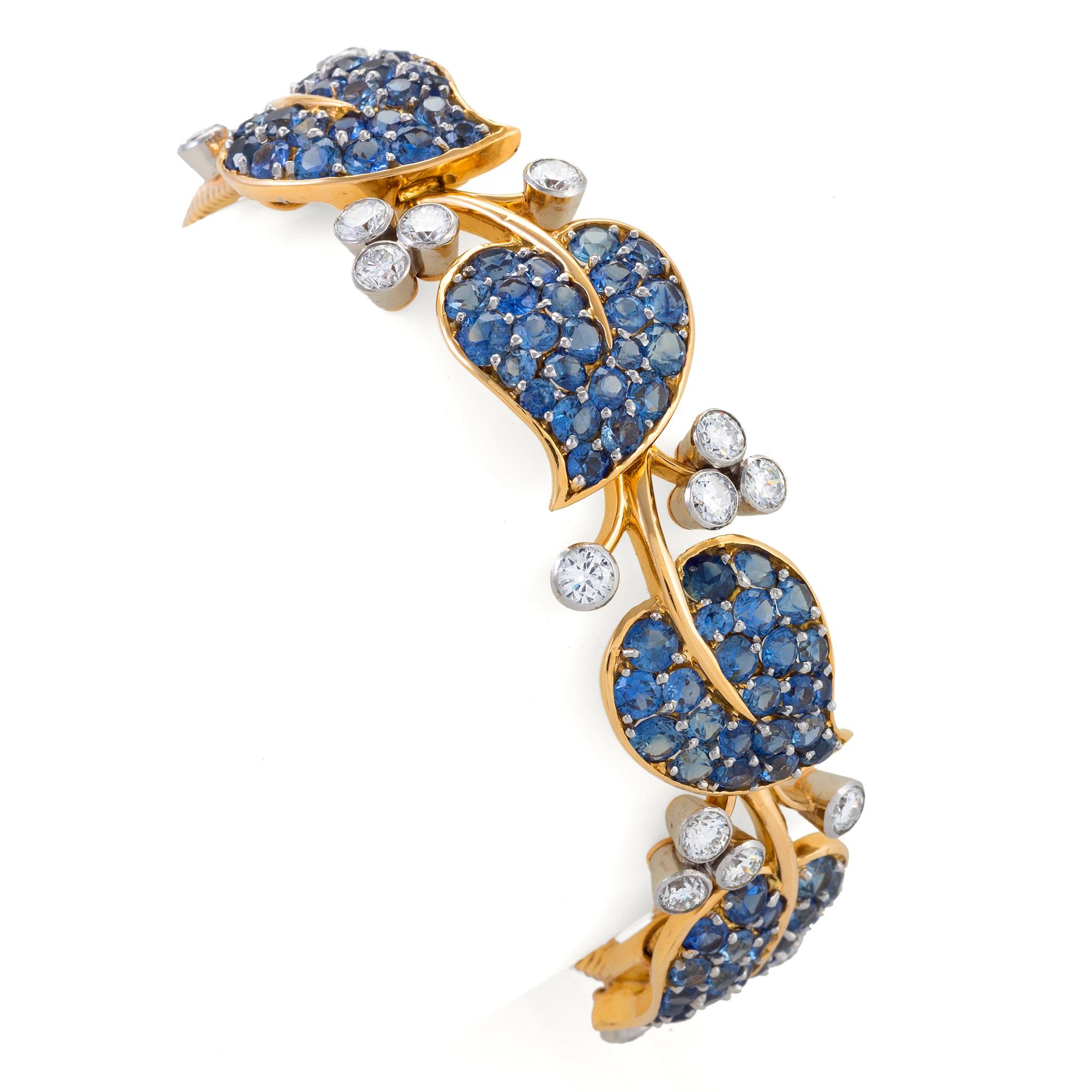 Set with Montana sapphires and diamonds, and mounted in 18K gold, this Van Cleef & Arpels New York bracelet dates from 1955. Designed a curving vine of pavé-set sapphire leaves joined by gold tendrils, and highlighted by clustered diamond buds and