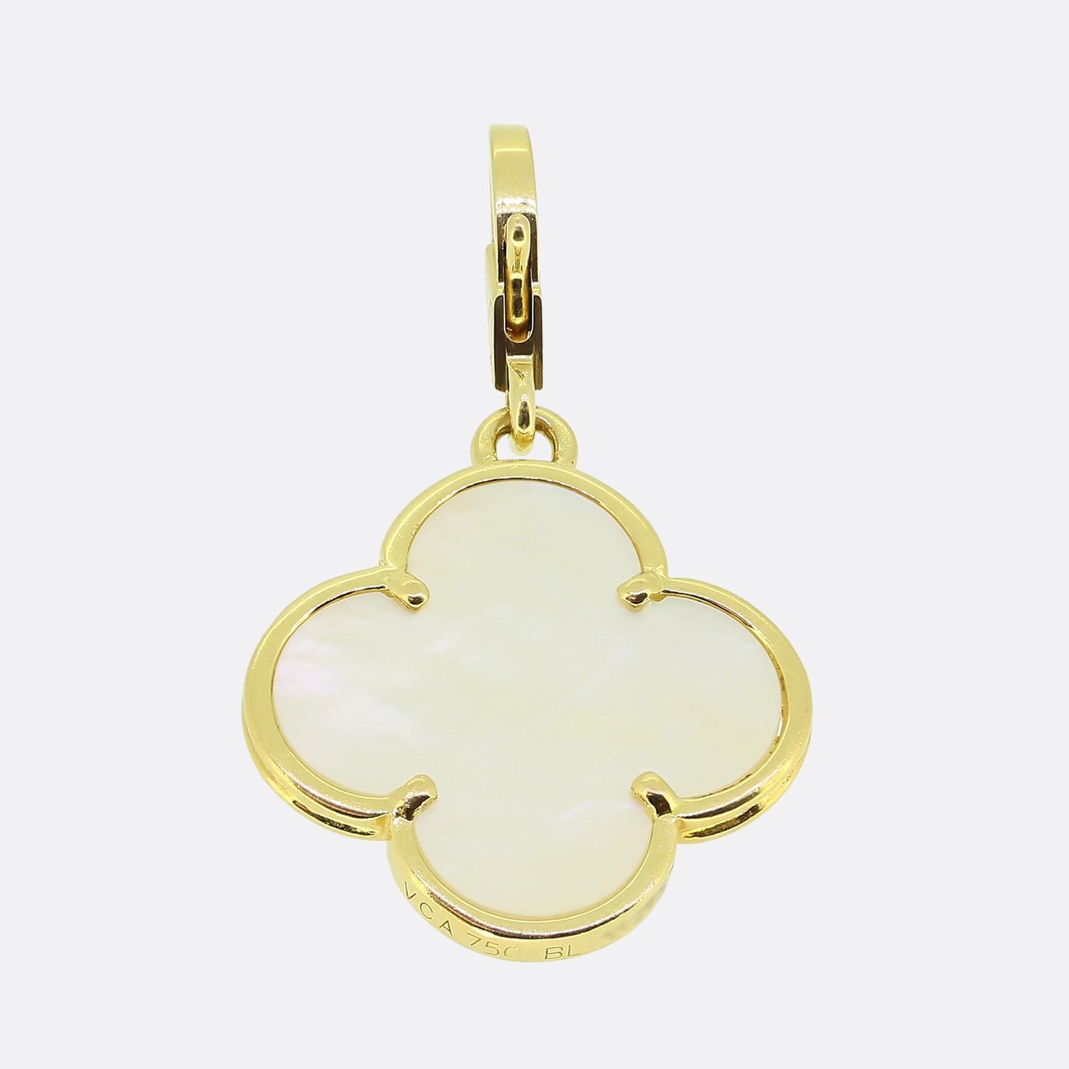 Hier haben wir einen ikonischen Alhambra-Anhänger aus dem weltbekannten Luxusschmuckhaus Van Cleef & Arpels. Dieser Anhänger aus 18-karätigem Gelbgold zeigt eine Kleeblattform mit einer weißen Perlmuttintarsie, bevor die VCA-Signatur am Bügel das