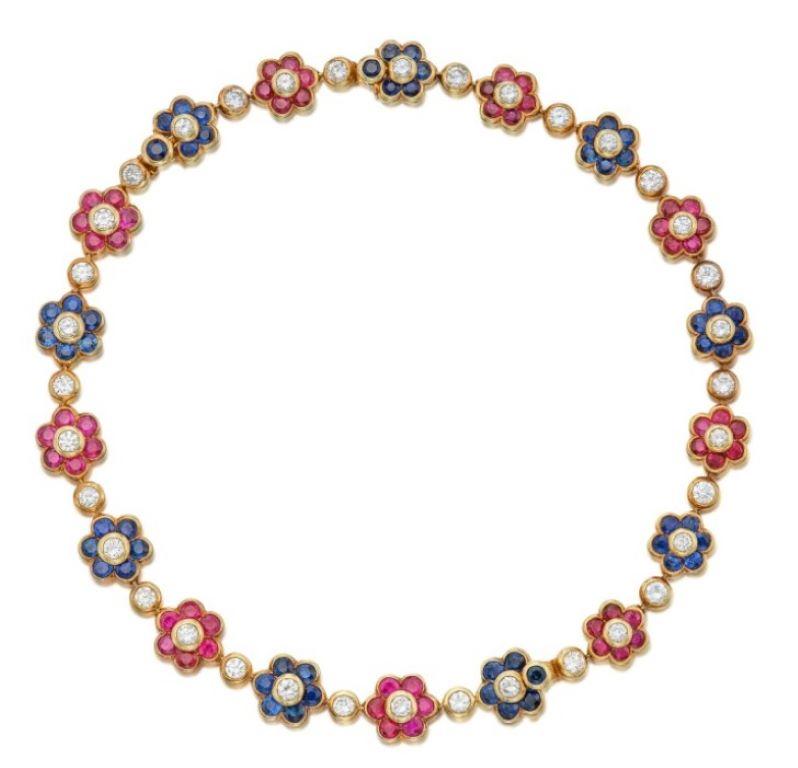Van Cleef & Arpels Multi Gem & Diamond Floral Necklace, this necklace features a combination of sapphires, rubies, and diamonds in a necklace design. It showcases a delightful flower motif with round-cut bezel links connecting to each other.