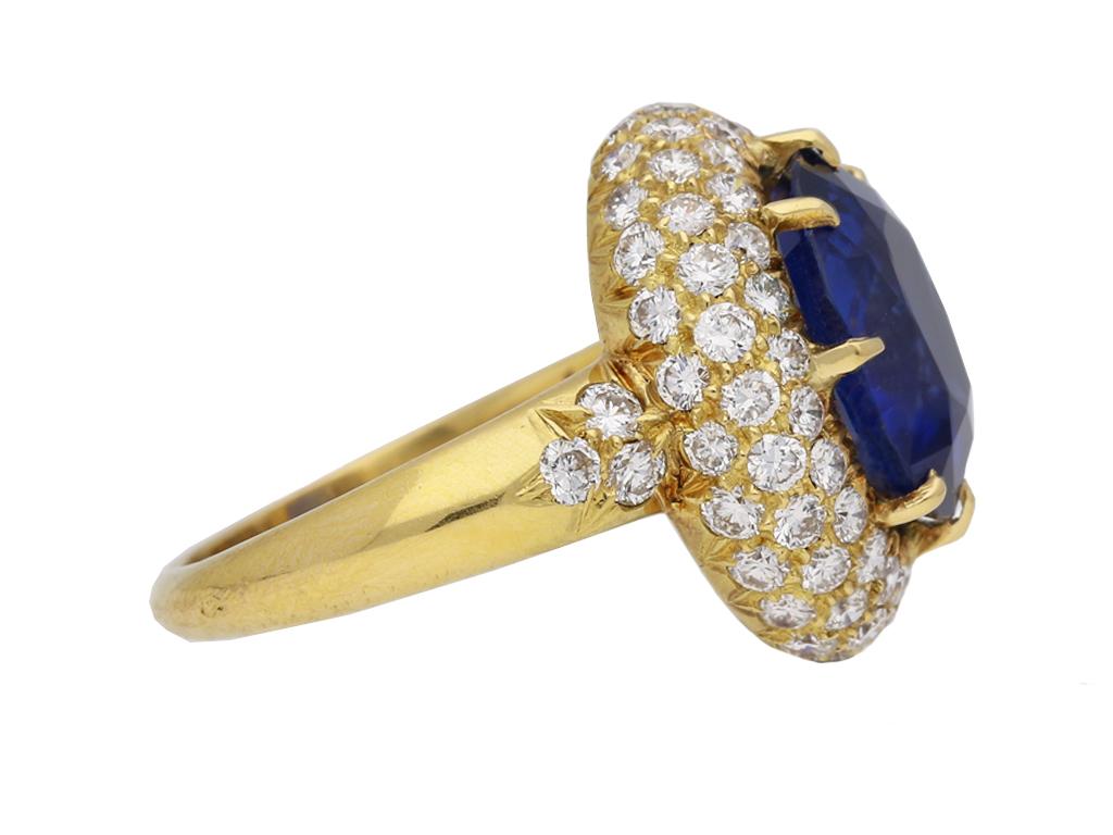 Van Cleef & Arpels Burmese sapphire and diamond cluster ring. Set with a natural unenhanced oval old cut Burmese sapphire to centre in an open back claw setting with an approximate weight of 5.56 carats, encircled by three rows of round brilliant