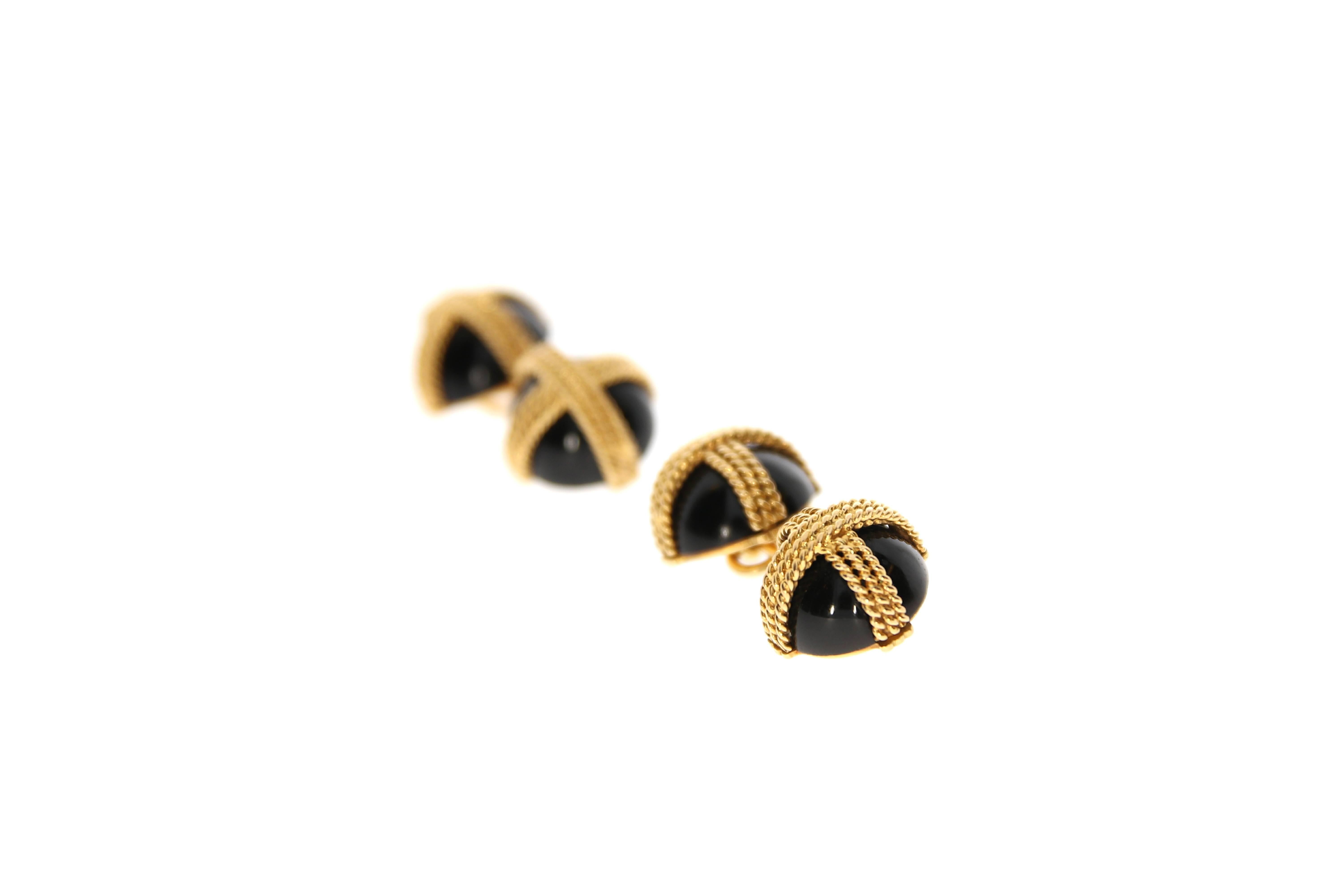 An elegant pair of onyx cufflinks, by Van Cleef and Arpels. Each cabochon onyx terminal is encased within a woven 18 Karat yellow gold cross frame. Signed VCA, numbered #B4083 and French assay marks.