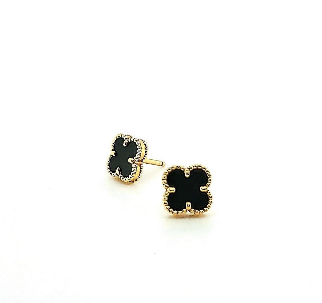 Authentic Van Cleef & Arpels 'Sweet' Alhambra motif ear studs crafted in 18 karat yellow gold and set with carved onyx clovers. The earrings measure 9mm x 9mm. Earrings are signed VCA, Au 750 with serial number. Earring push backs are original. Does