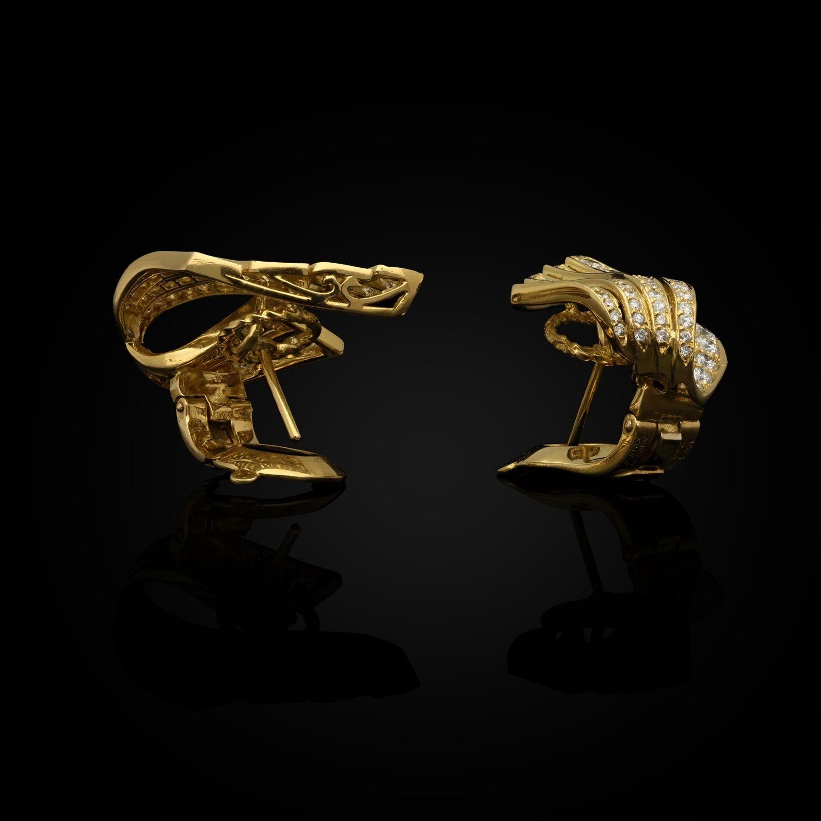 A stylish pair of 18ct yellow gold and diamond earrings by Van Cleef & Arpels c.1990s, designed as a three-dimensional stylised wing with a flared shape pointed at the top tapering towards the base which curls under and behind, offset to one side,