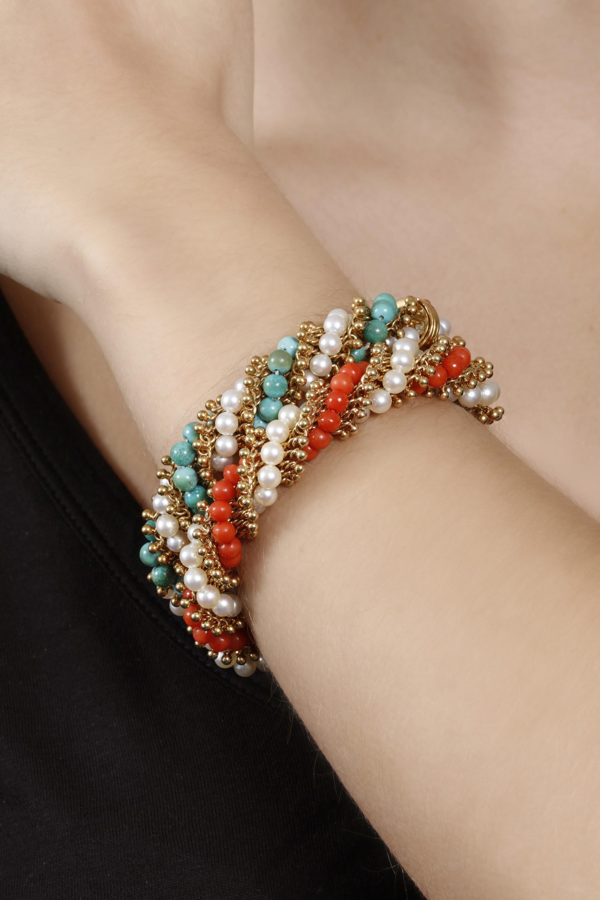 A pair of Van Cleef & Arpels Twist bracelets, each set with cultured pearls and with coral and turquoise beads respectively. Length approximately 200mm, each signed VCA, numbered, French assay marks for gold and indistinct maker's mark. 
