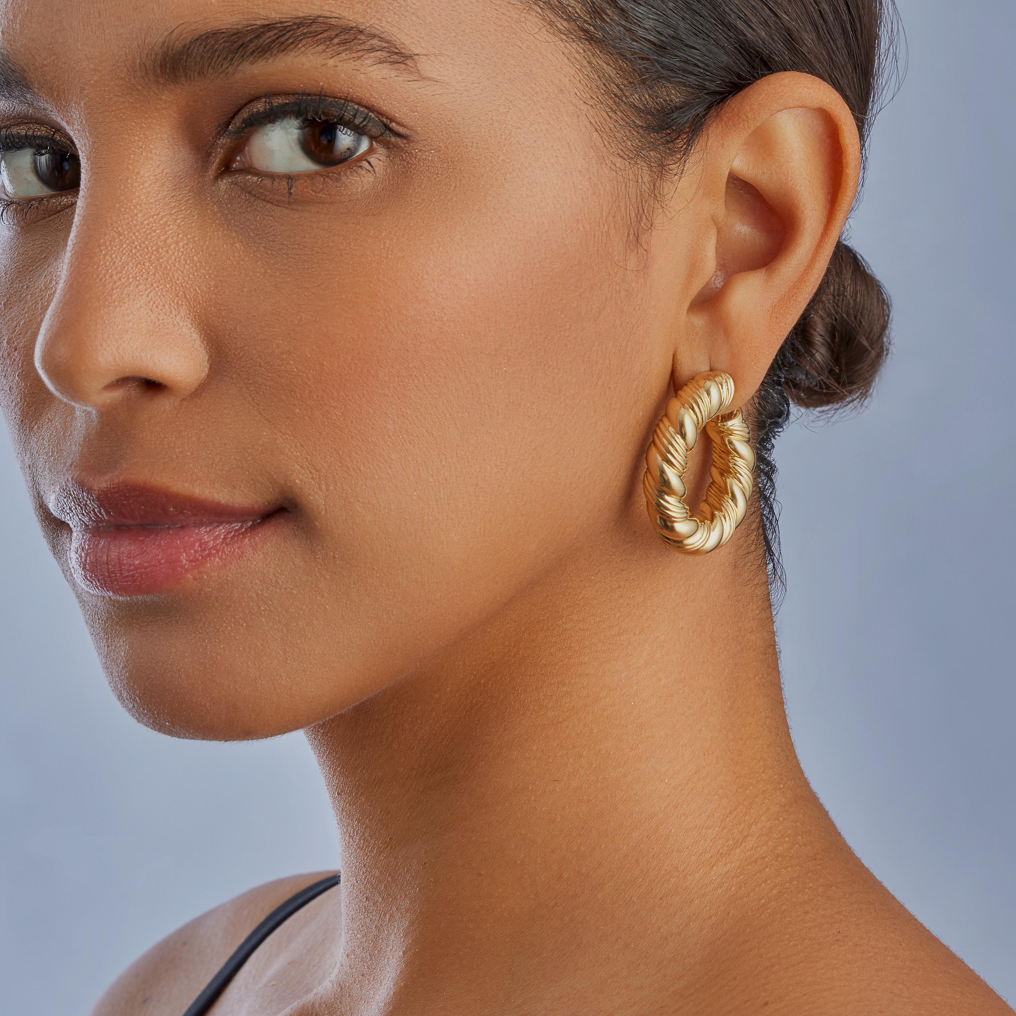 These Van Cleef & Arpels Paris hoop clip earrings in 18K gold date from the 1980s. Each is designed as a ropetwist pattern, ribbed hoop. Designed to hang so that the hoop faces forward, showcasing the circular form and dynamic patterning, these chic