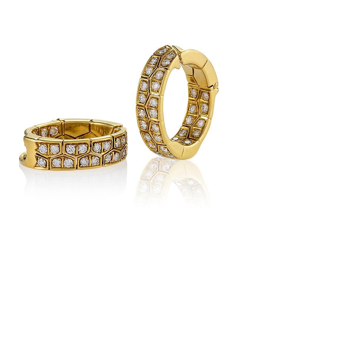 A pair of French Late-20th Century 18 karat gold earrings with diamonds by Van Cleef & Arpels. The hoop earrings have 60 round diamonds with an approximate total weight of 3.00 carats, F-G color, VS clarity.  The earrings are designed in a modernist