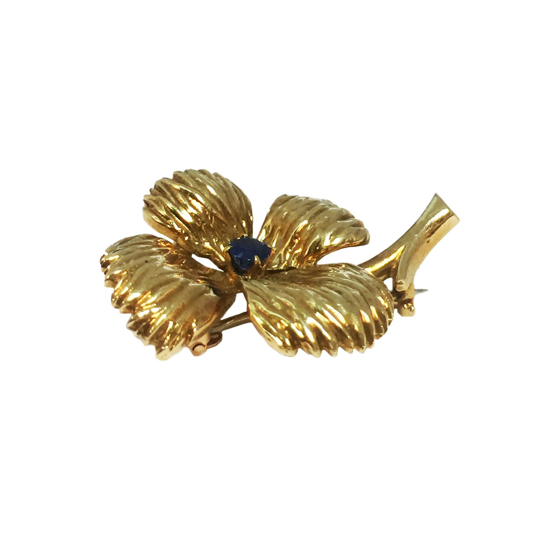 Circa 1960 Van Cleef & Arpels Paris, 18K yellow Gold Flower Clip Brooch, measuring 1 1/8 X 7/8 inch and centrally set with a round faceted Sapphire. Having French Hallmarks and comes in the original VCA Paris presentation box.
