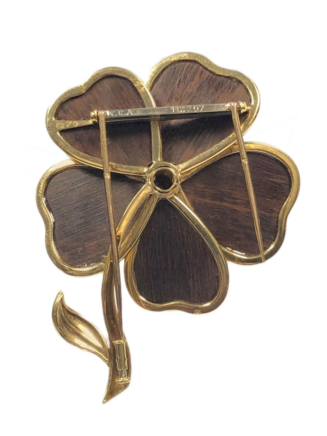 Circa 1970s Van Cleef & Arpels Paris 18k Yellow Gold Flower Clip Brooch, measuring 2 3/4 inches in length with the flower portion measuring 2 inches in diameter. 5 Wood Pedals and a center set with 3 Round Brilliant cut Diamonds totaling .15 Carat.