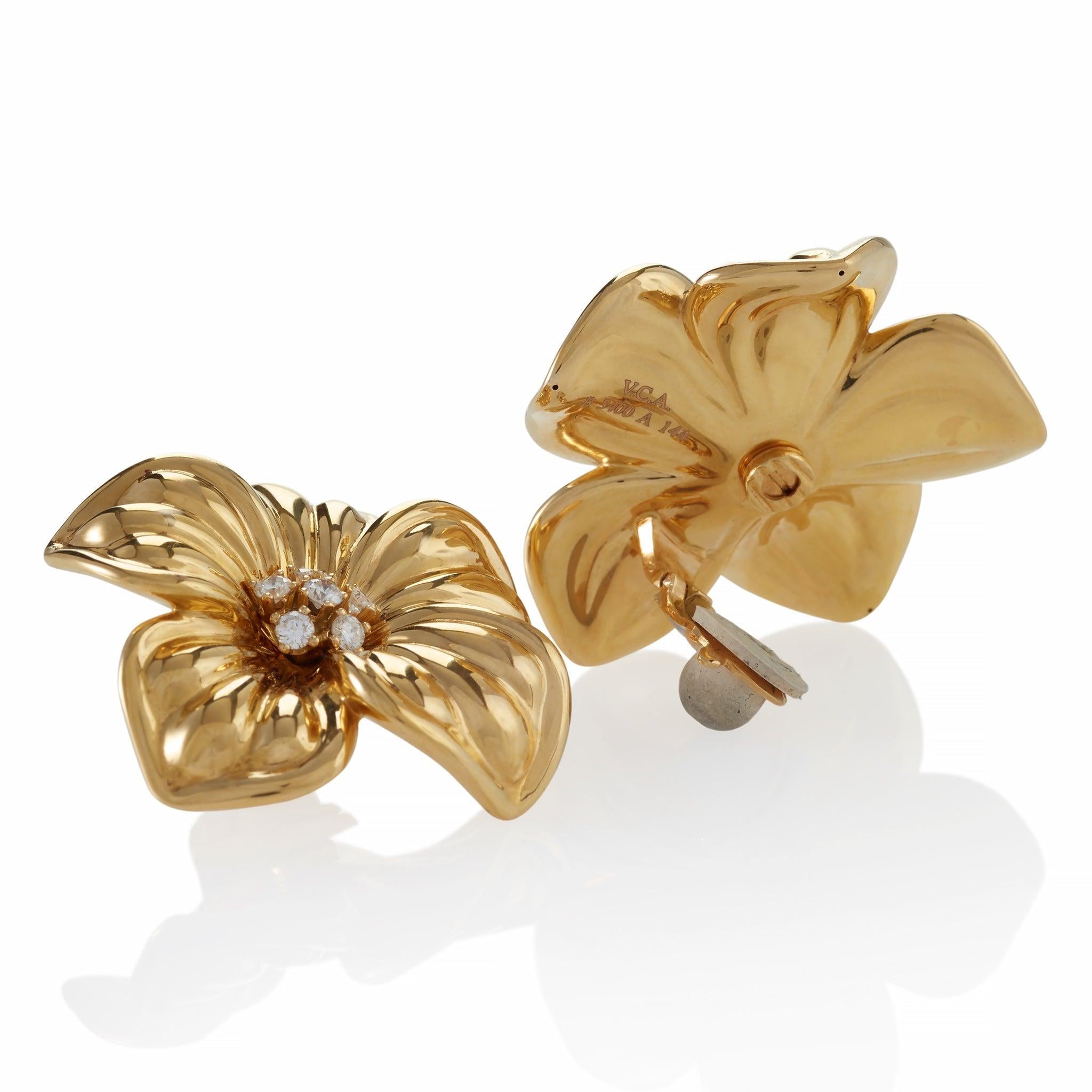 These oversized modern 18K gold and diamond flower clip earrings were created by Van Cleef & Arpels. Each is designed as a naturalistic five-petal magnolia blossom centering a cluster of round brilliant-cut diamonds. Oversized and luxe, these highly