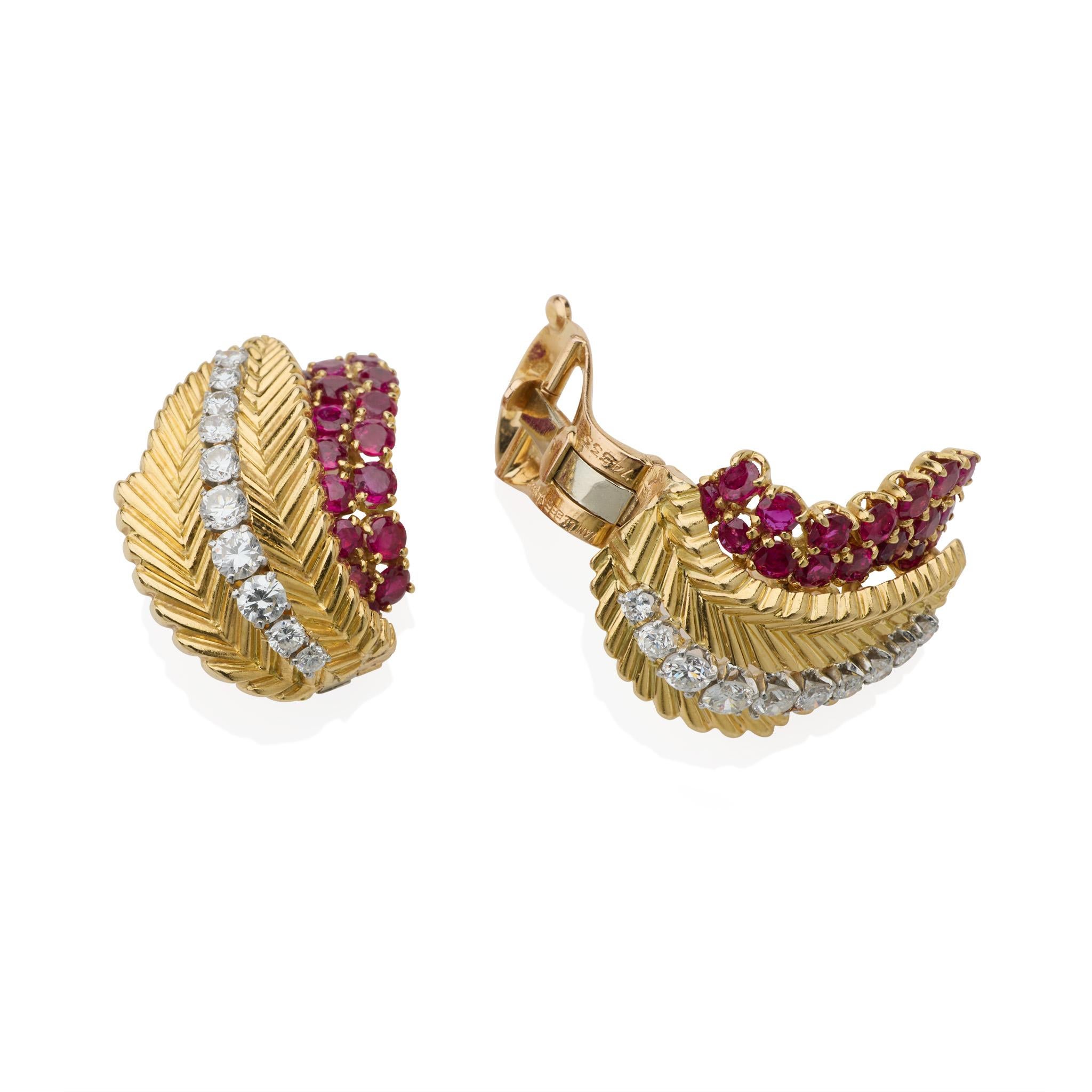 Created in the 1950s, the Van Cleef & Arpels Paris ruby and diamond clip earrings were manufactured by Pery & Fils. Each is designed as a ribbed gold leaf centering a line of round diamonds, layered over a field of round-cut rubies, with omega clip