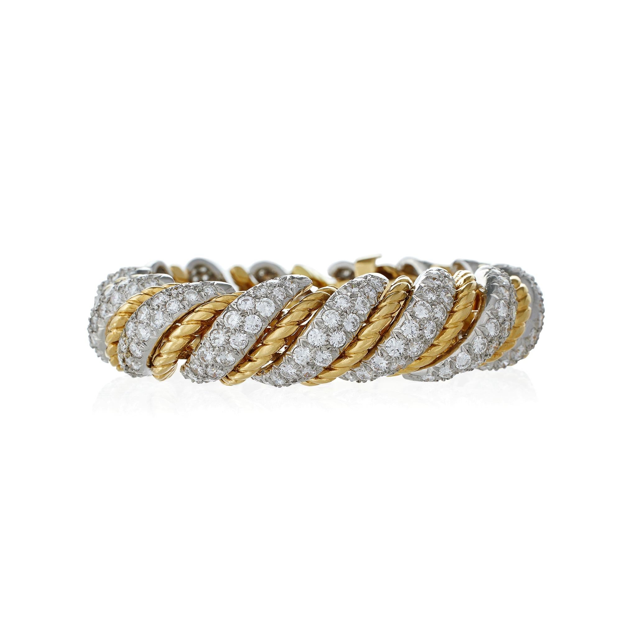 This Van Cleef & Arpels Paris bracelet dating from the 1960s-1970s is composed of diamonds set in 18K gold and platinum. The flexible domed form is designed as arched, bombé sections of round brilliant-cut diamonds pavé-set in platinum braided