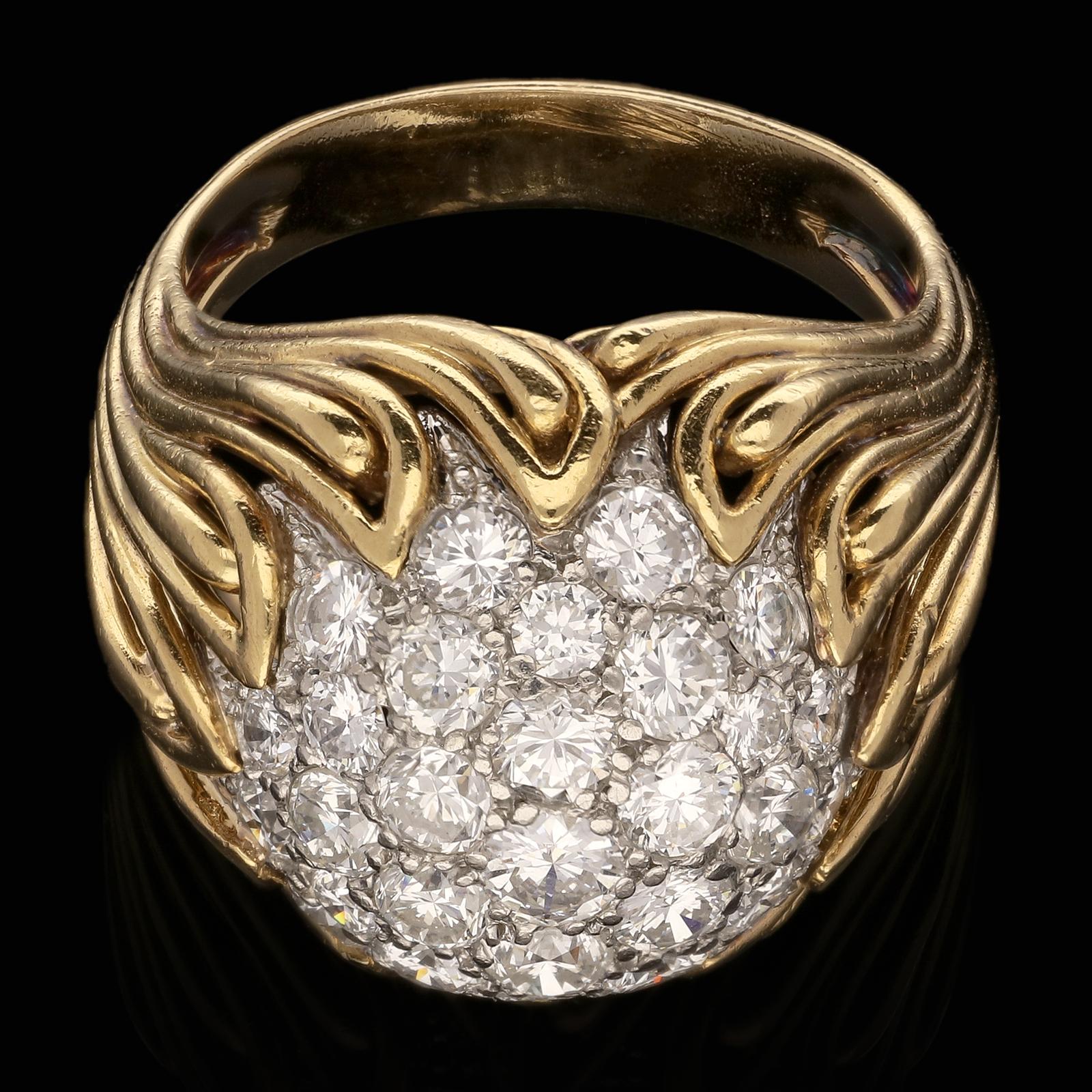 A beautiful diamond and gold bombe dress ring by Van Cleef & Arpels c.1959, centred with a circular dome of pavé set round brilliant cut diamonds in platinum surrounded by an 18ct yellow gold openwork mount of flame-like design, formed of multiple